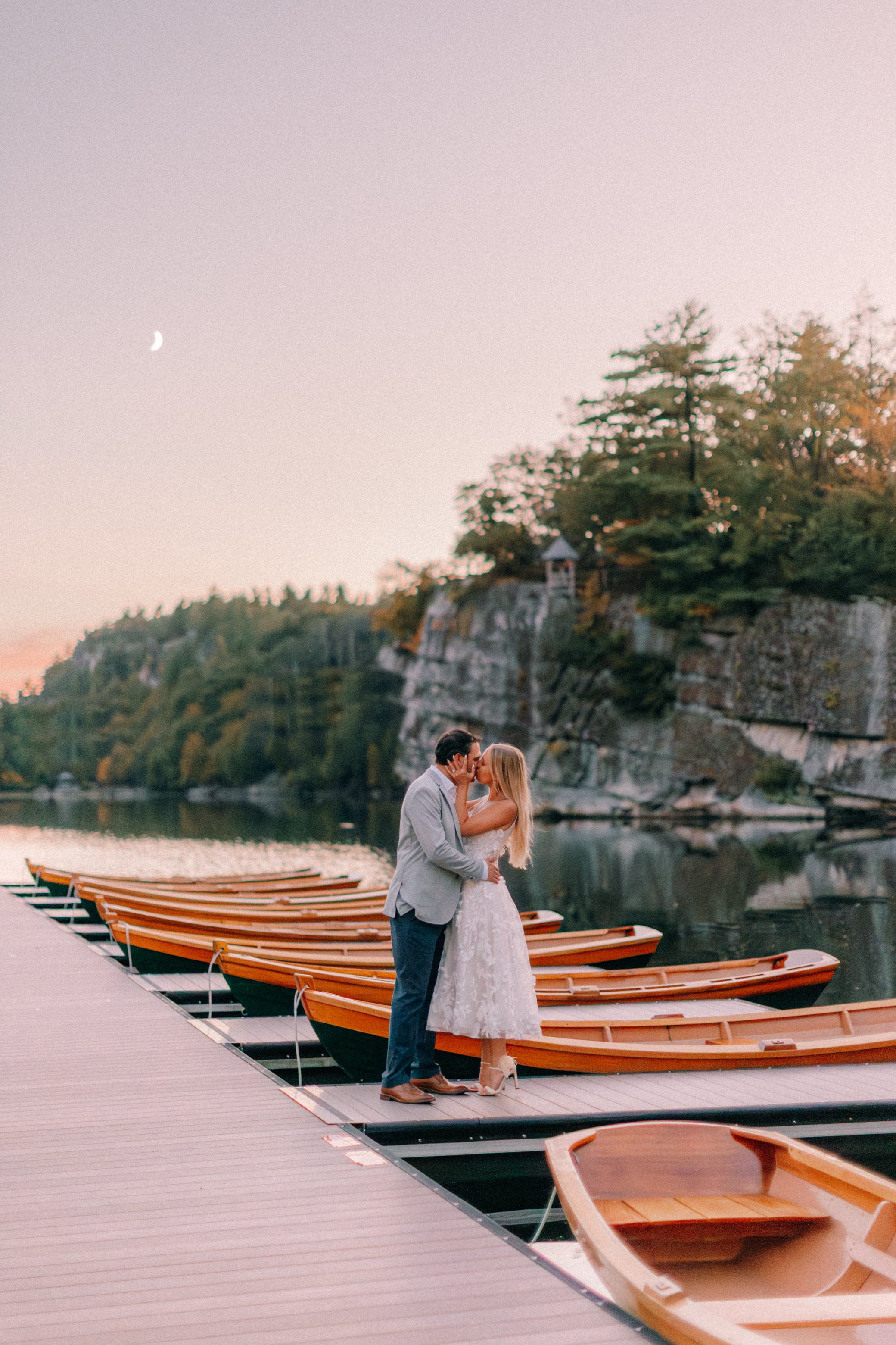 Newly engaged couple embrace on the docks of Mohonk Mountain House during their surprise proposal photography shoot