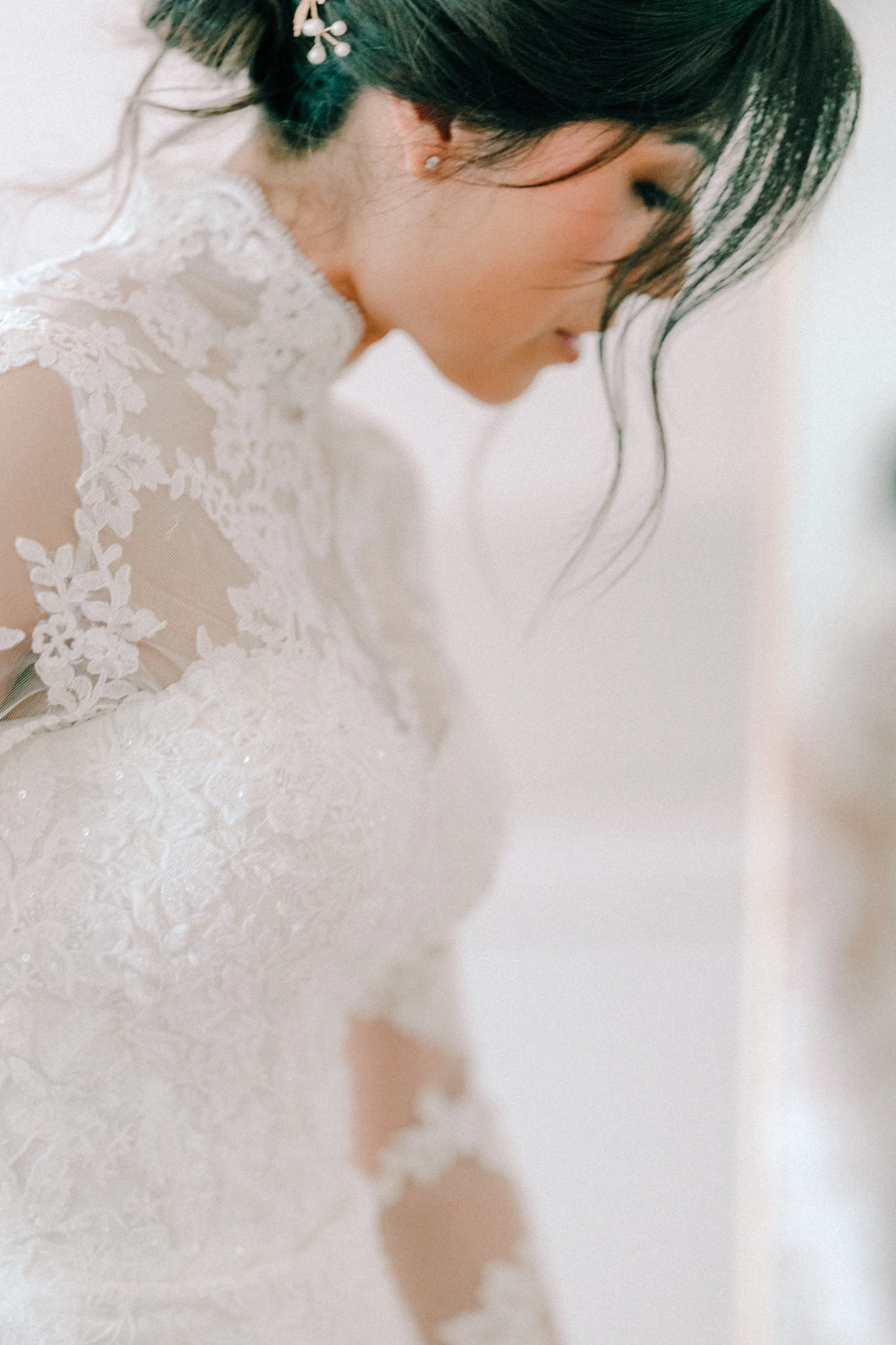 photograph of bride looking down wearing long sleeve high neck lace wedding dress