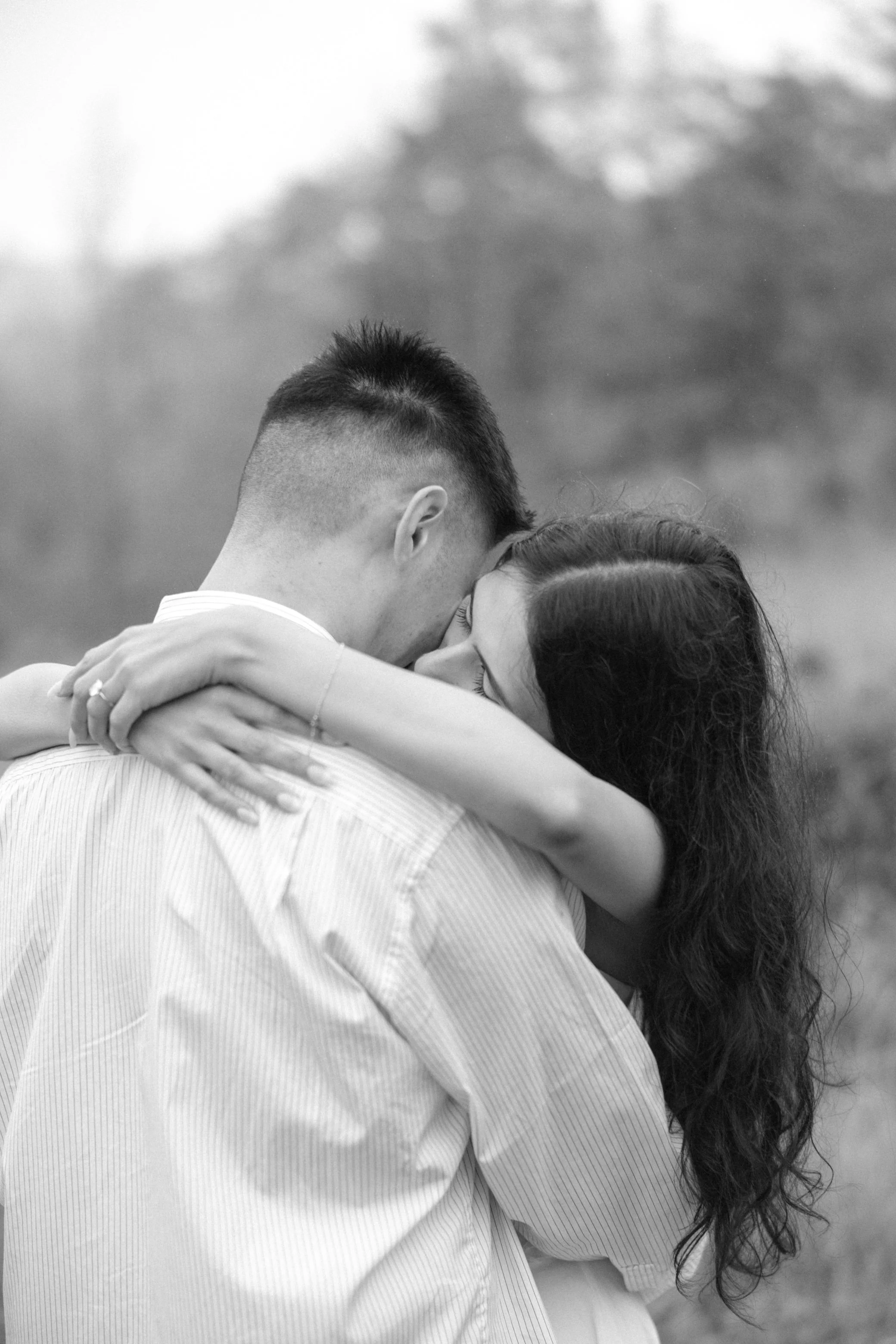 engaged couple embraces after he just proposed to her in the rain at kenoza hall