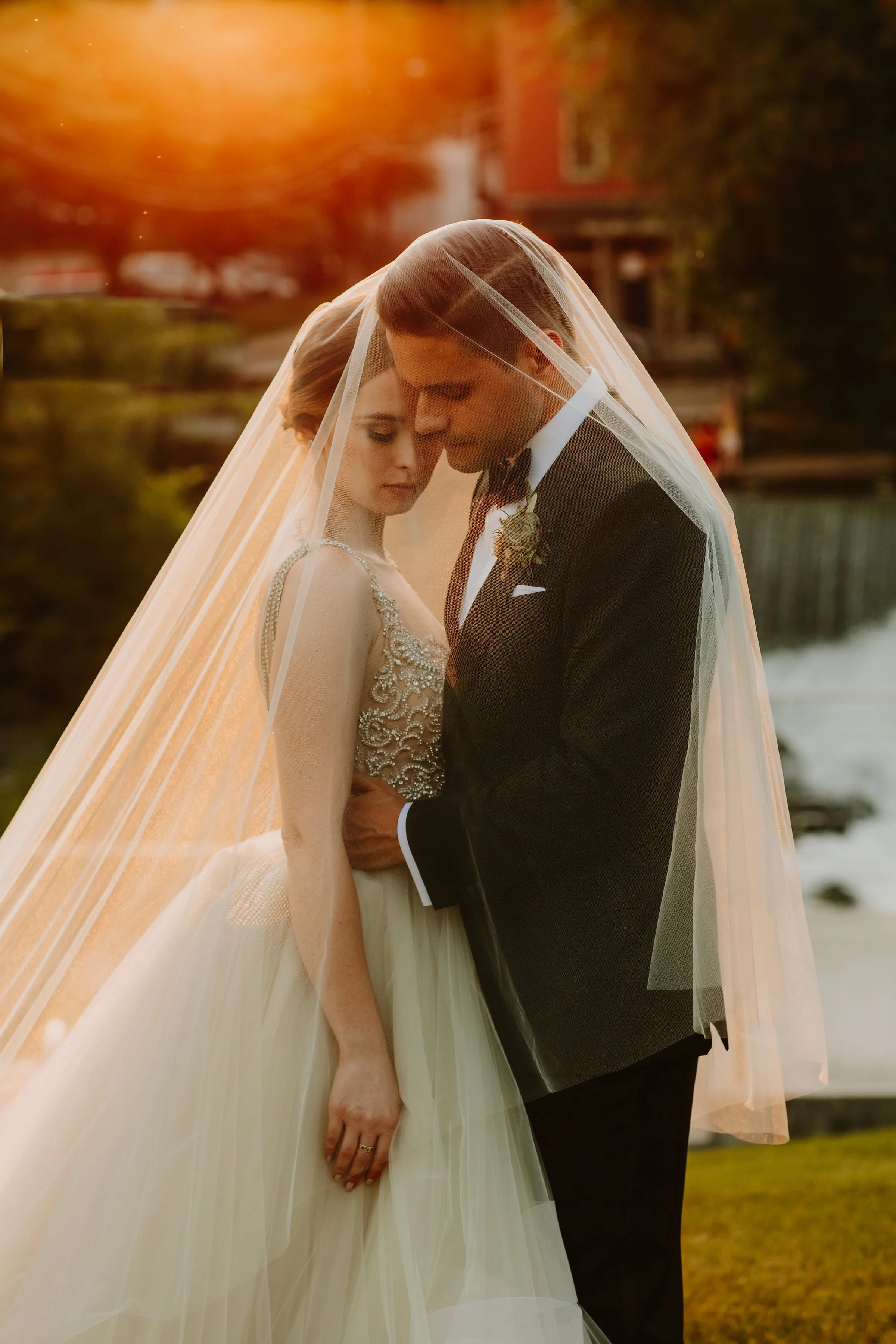 wedding couple under the brides veil during golden hour at the roundhouse in beacon ny
