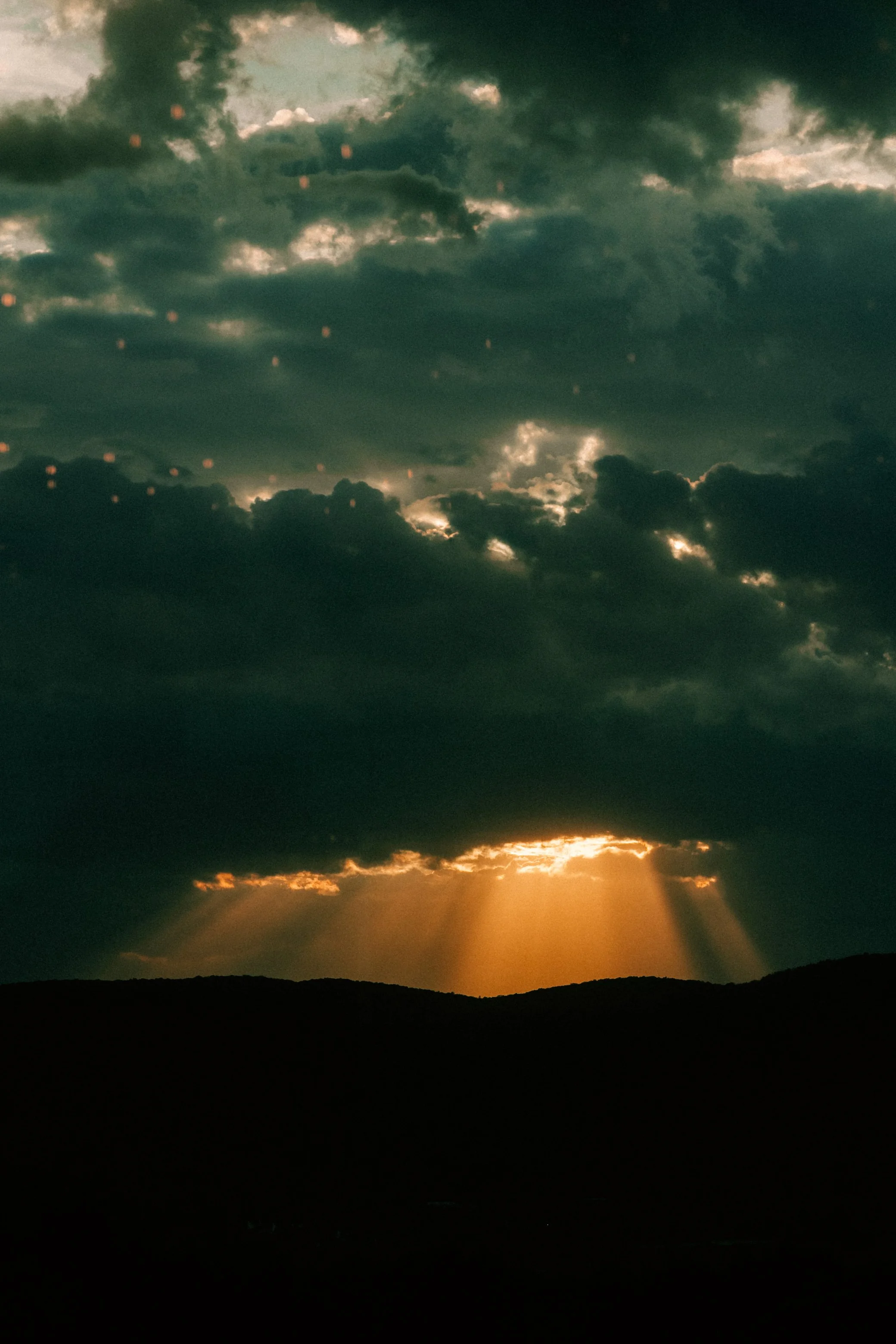 sun breaking through the dark clouds on a wedding day at the garrison
