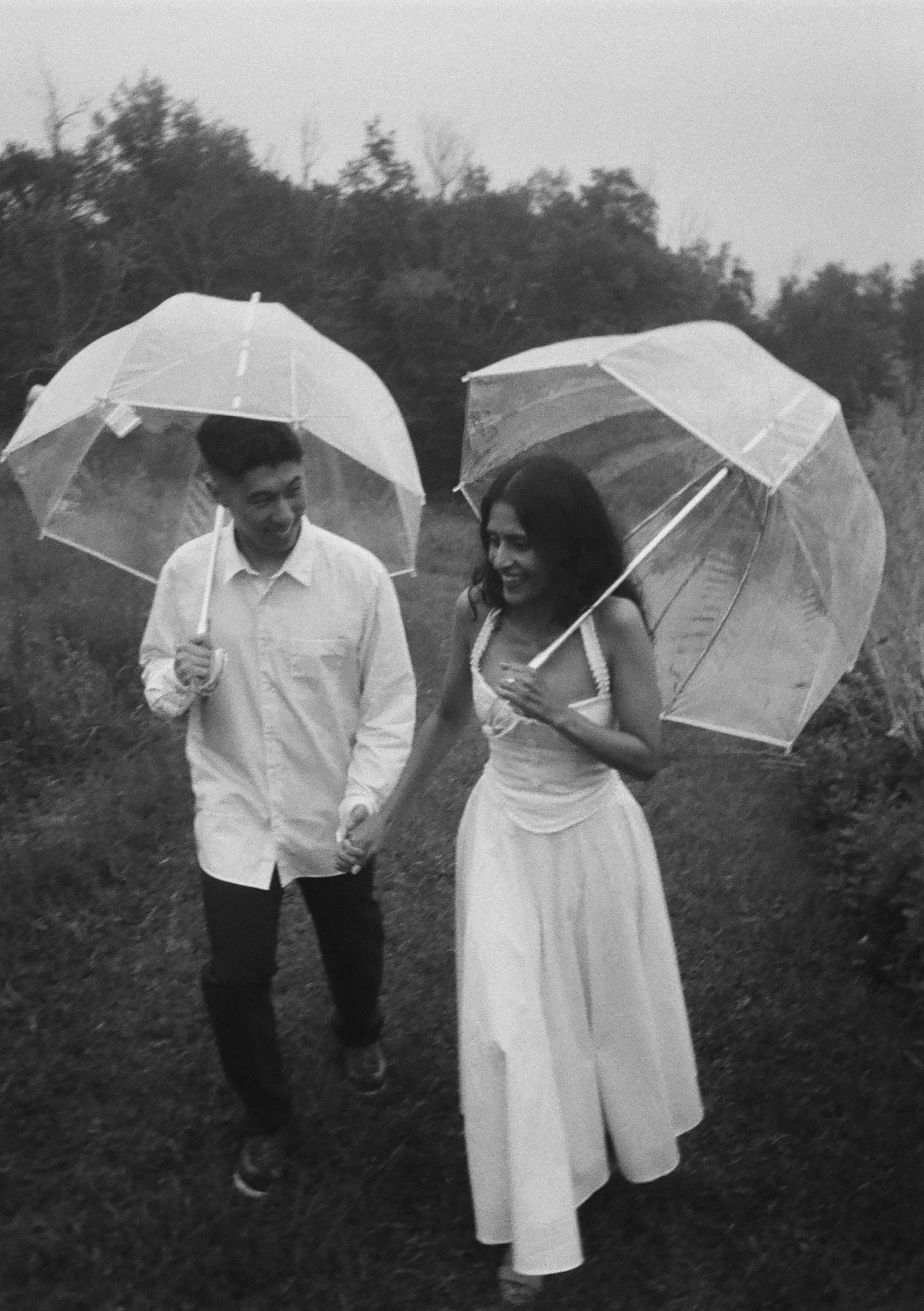 engaged couple walking through the rain during their surprise proposal at kenoza hall