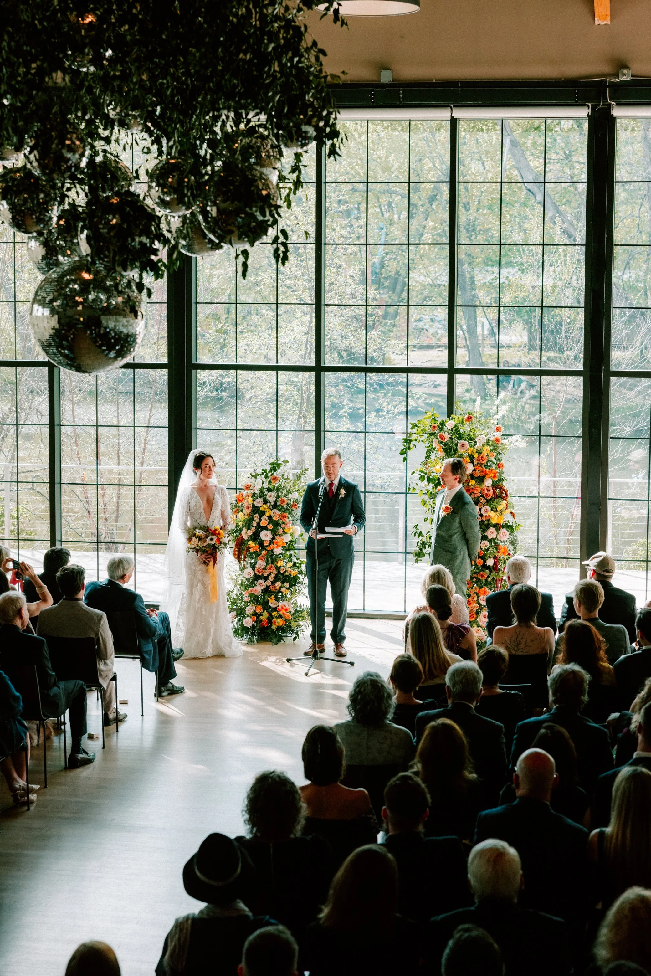 couple standing in front of florals during their wedding ceremony at the roundhouse