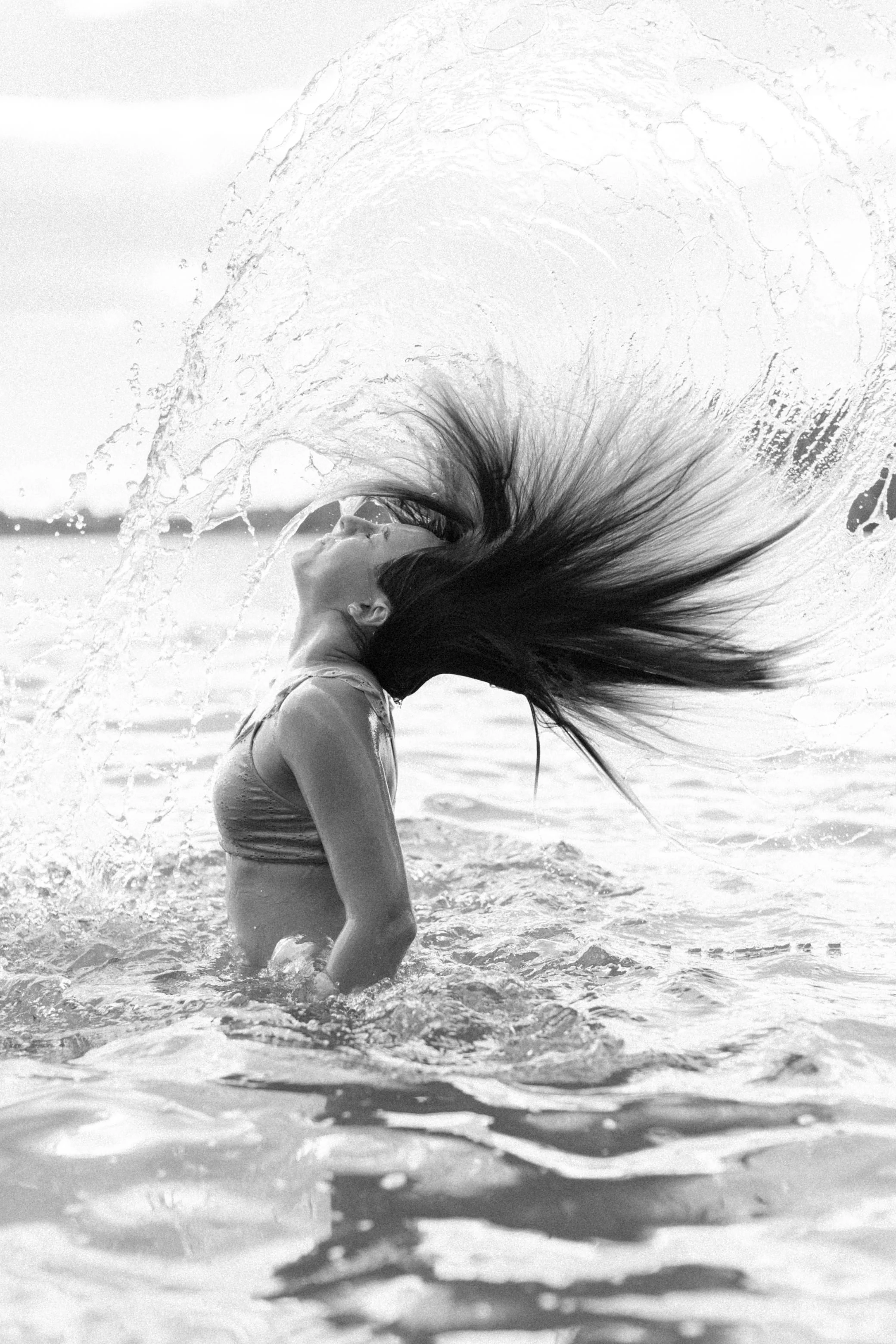 woman flips her hair in the water