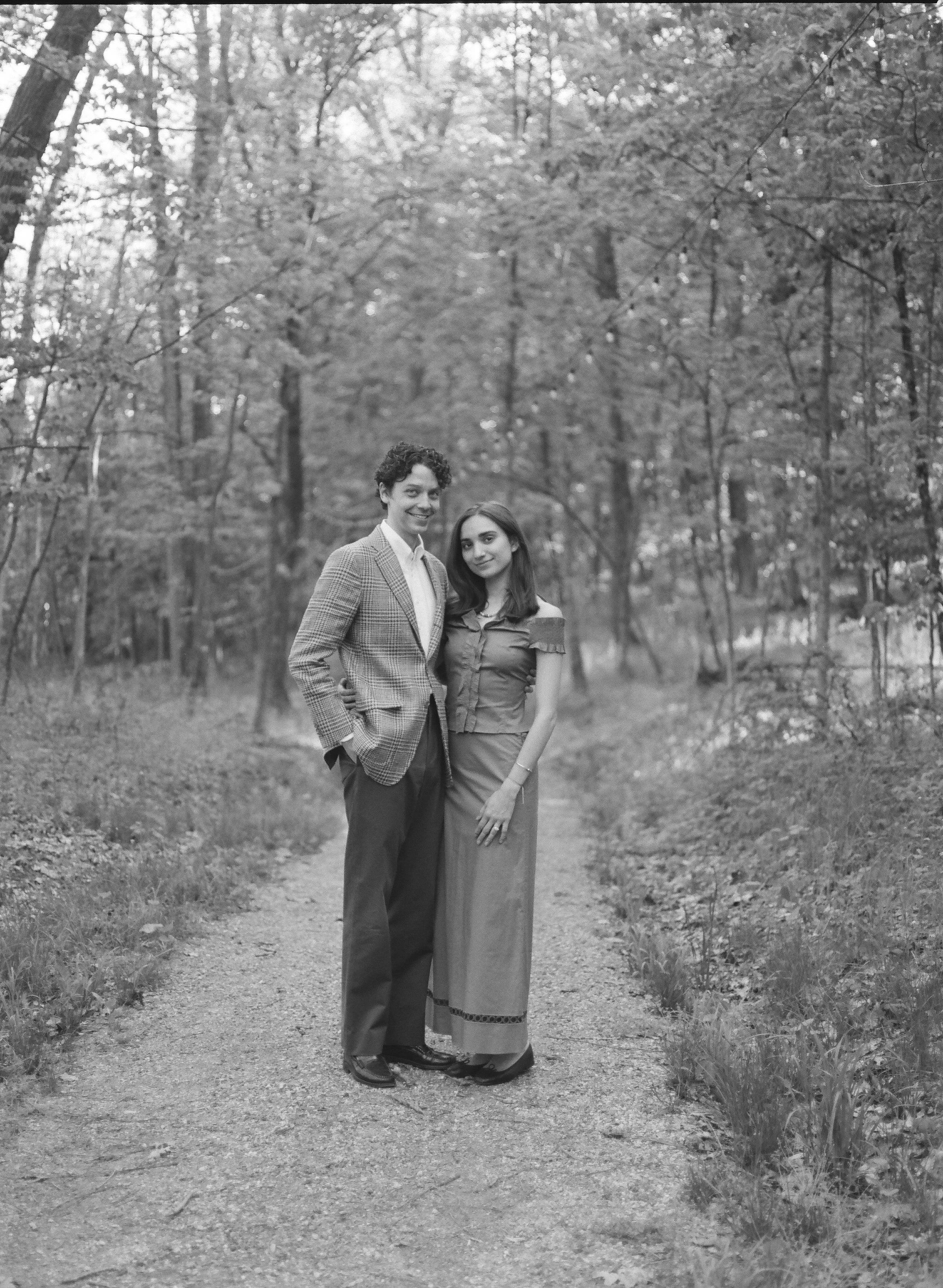 engaged couple standing on a path in the woods after he just proposed to her at camptown new york