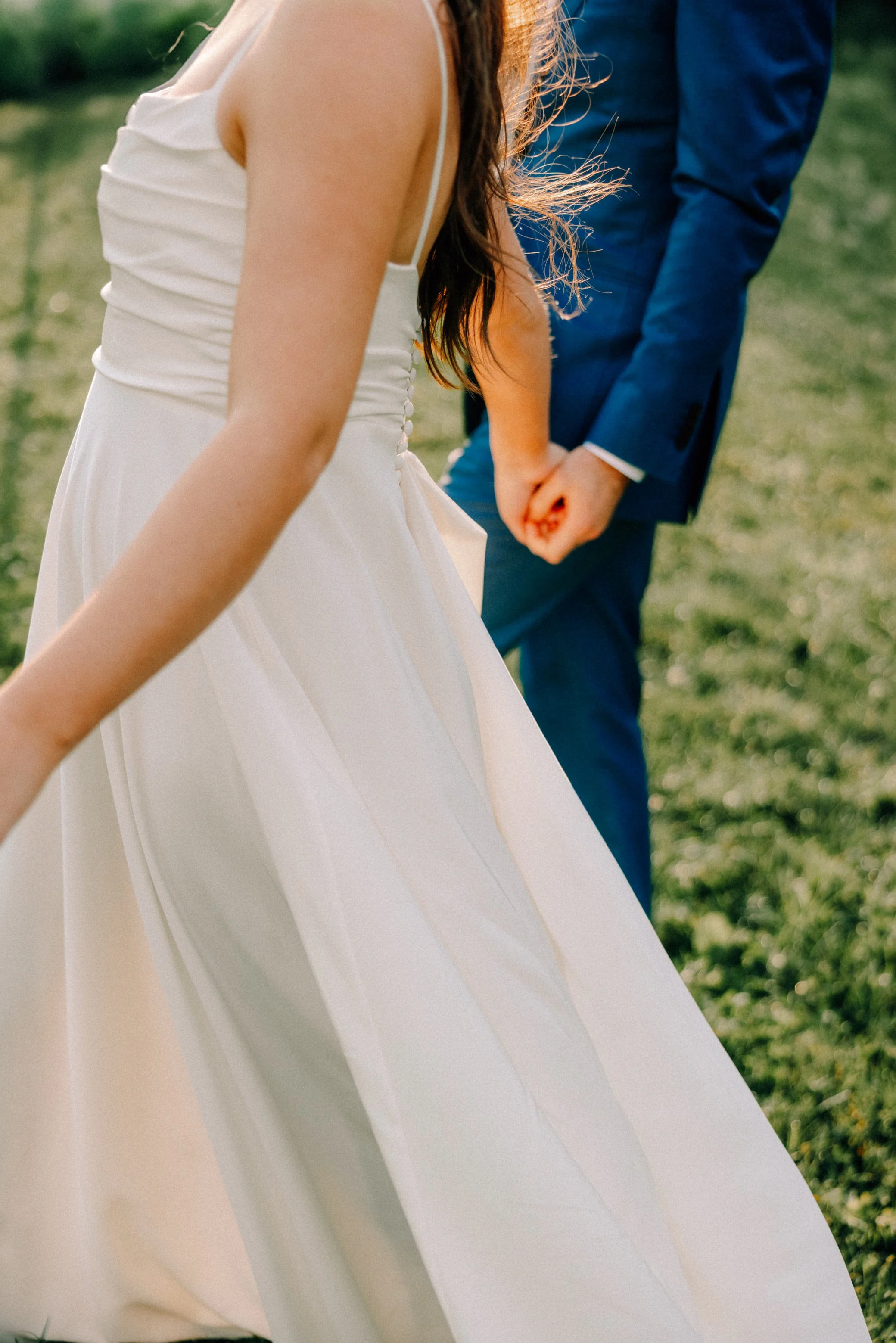 wedding couple hold hands and walk into a field at gather greene