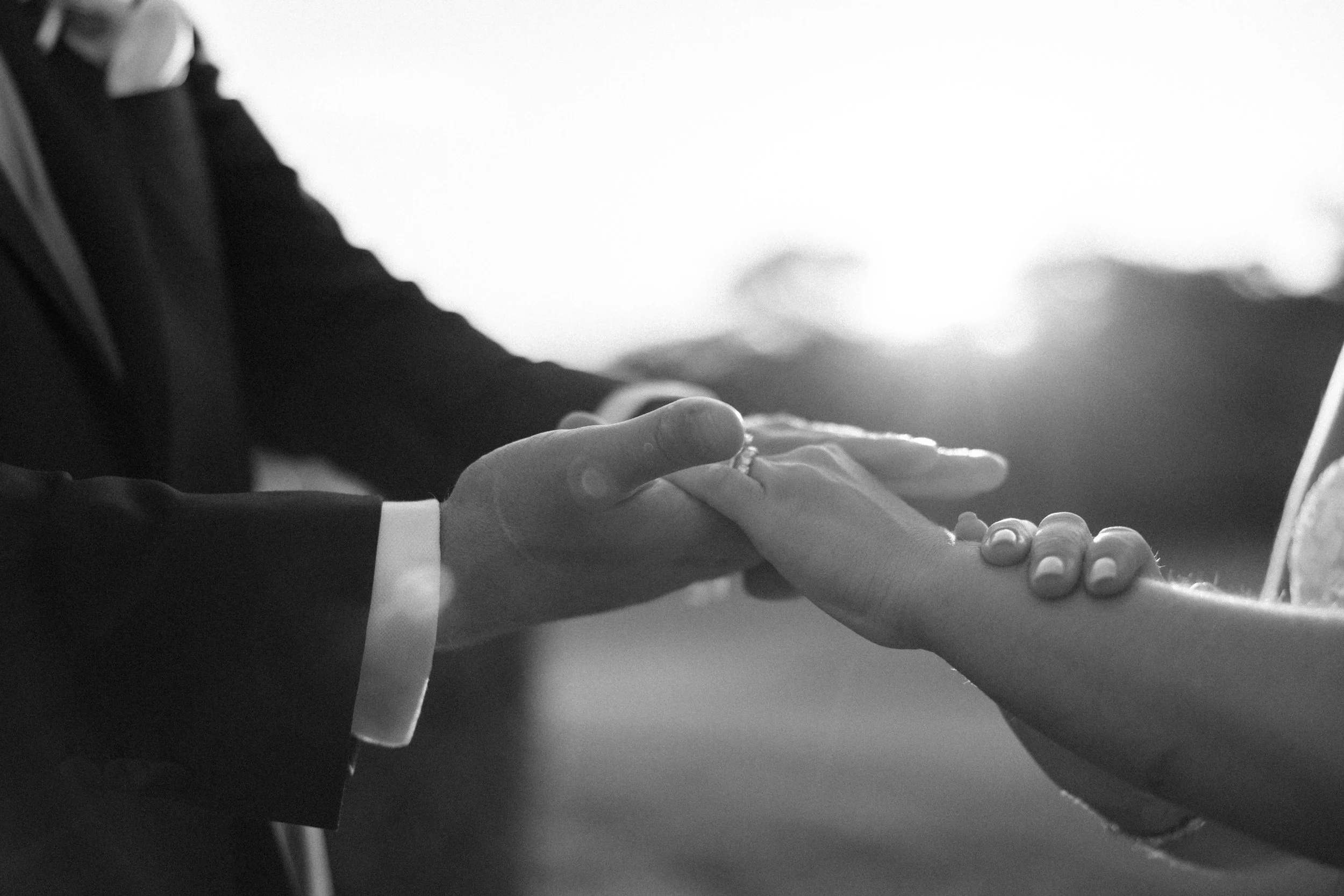 black and white photograph of bride and groom holding hands with holden hour sun behind them on their hudson valley wedding day at glenmere mansion