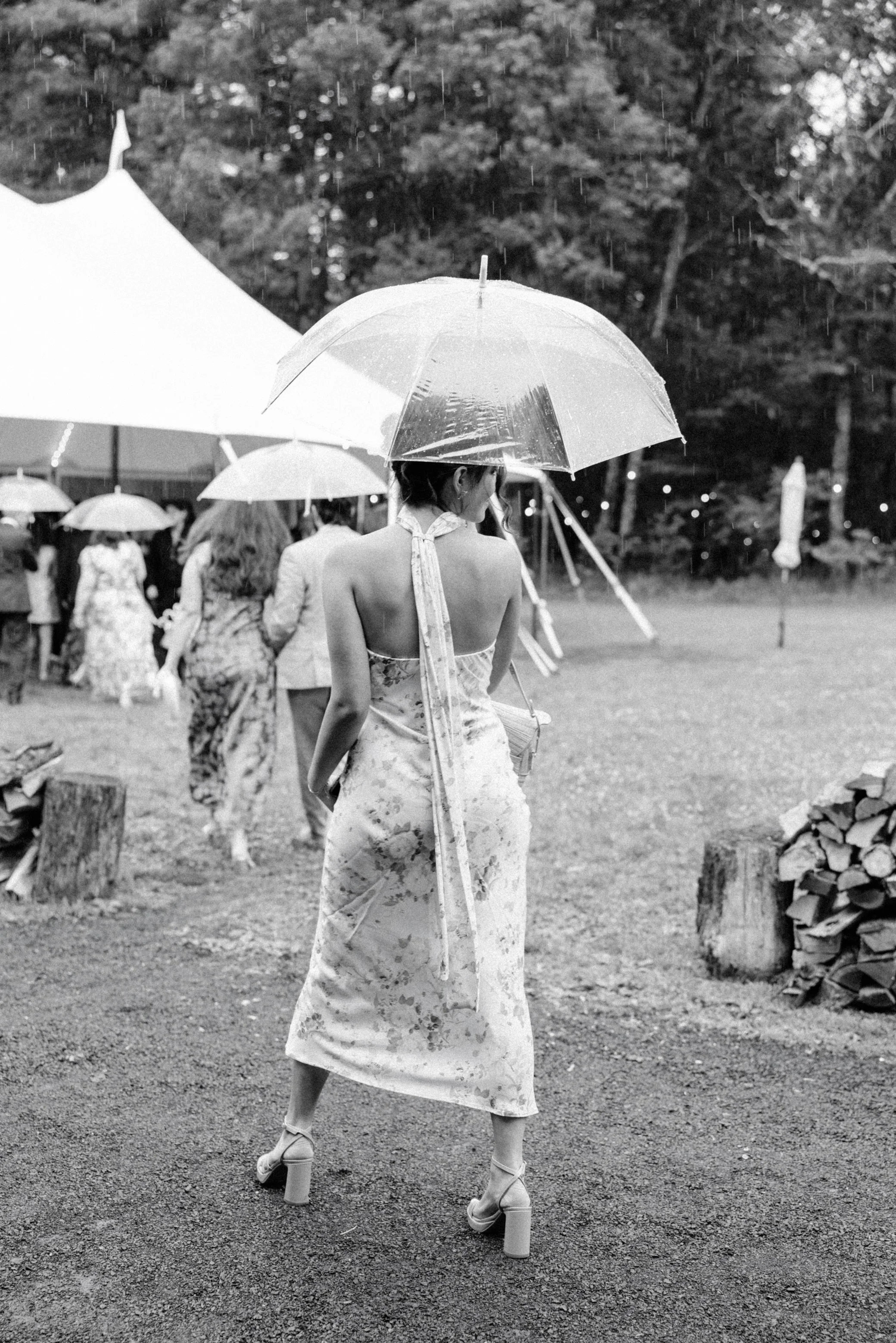 wedding guest walks with clear umbrella during cocktail hour at gather greene