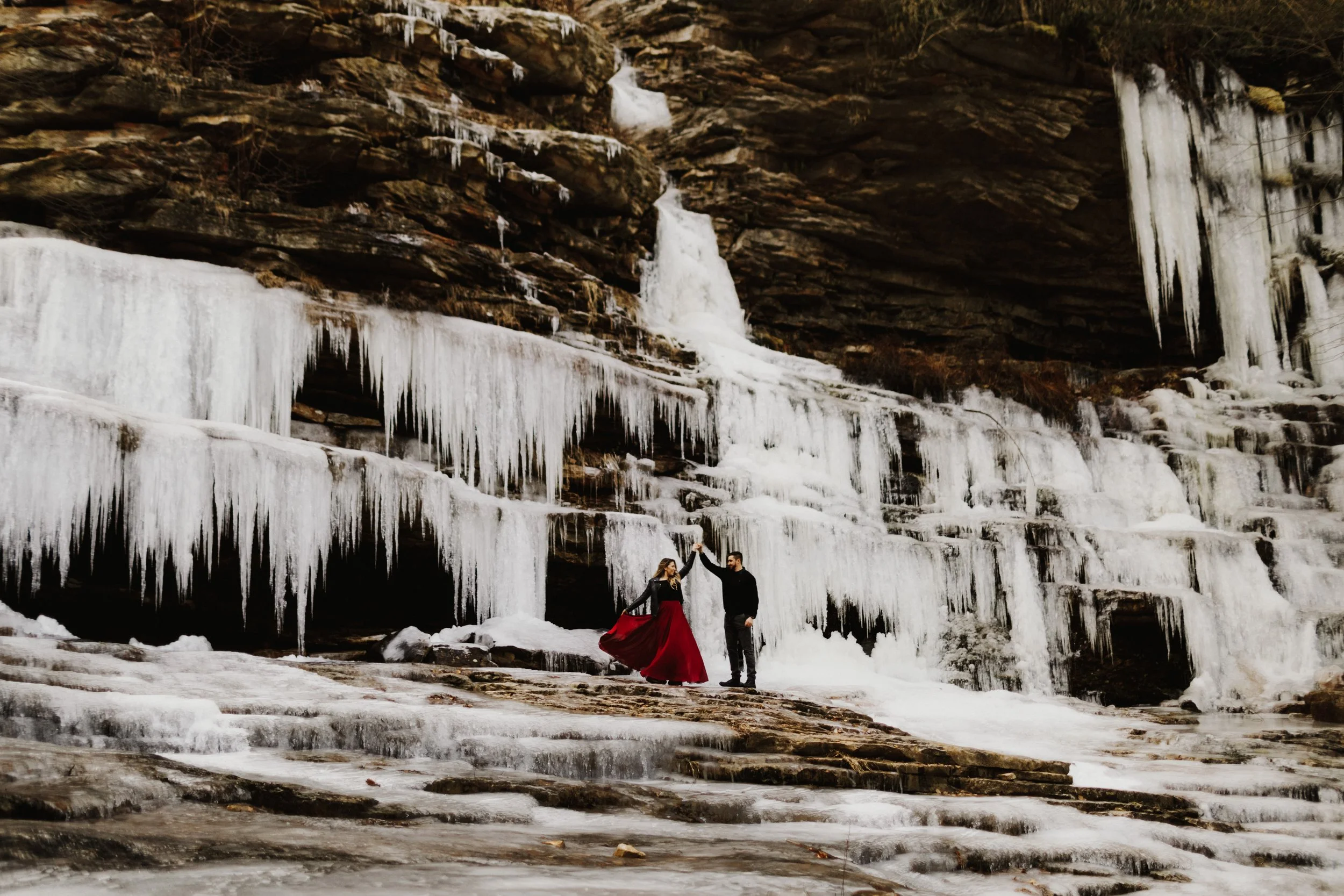 Couple dancing on frozen waterfall during their engagement shoot at minnewaska state park