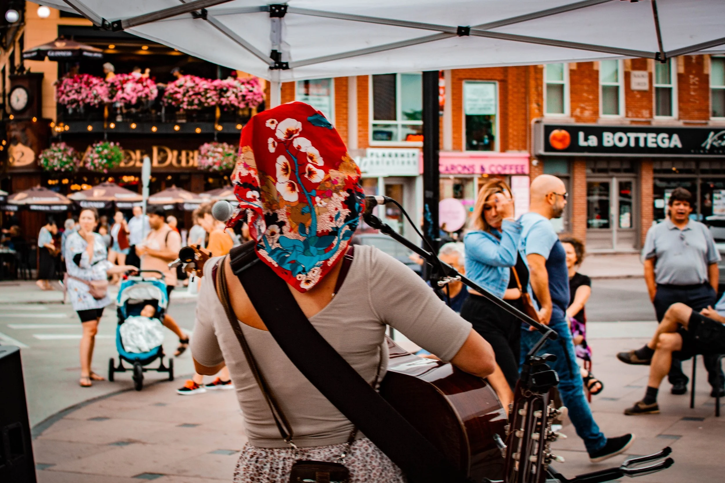 Un musicien qui chante et joue de la guitare pour les passants dans le quartier du marché By.