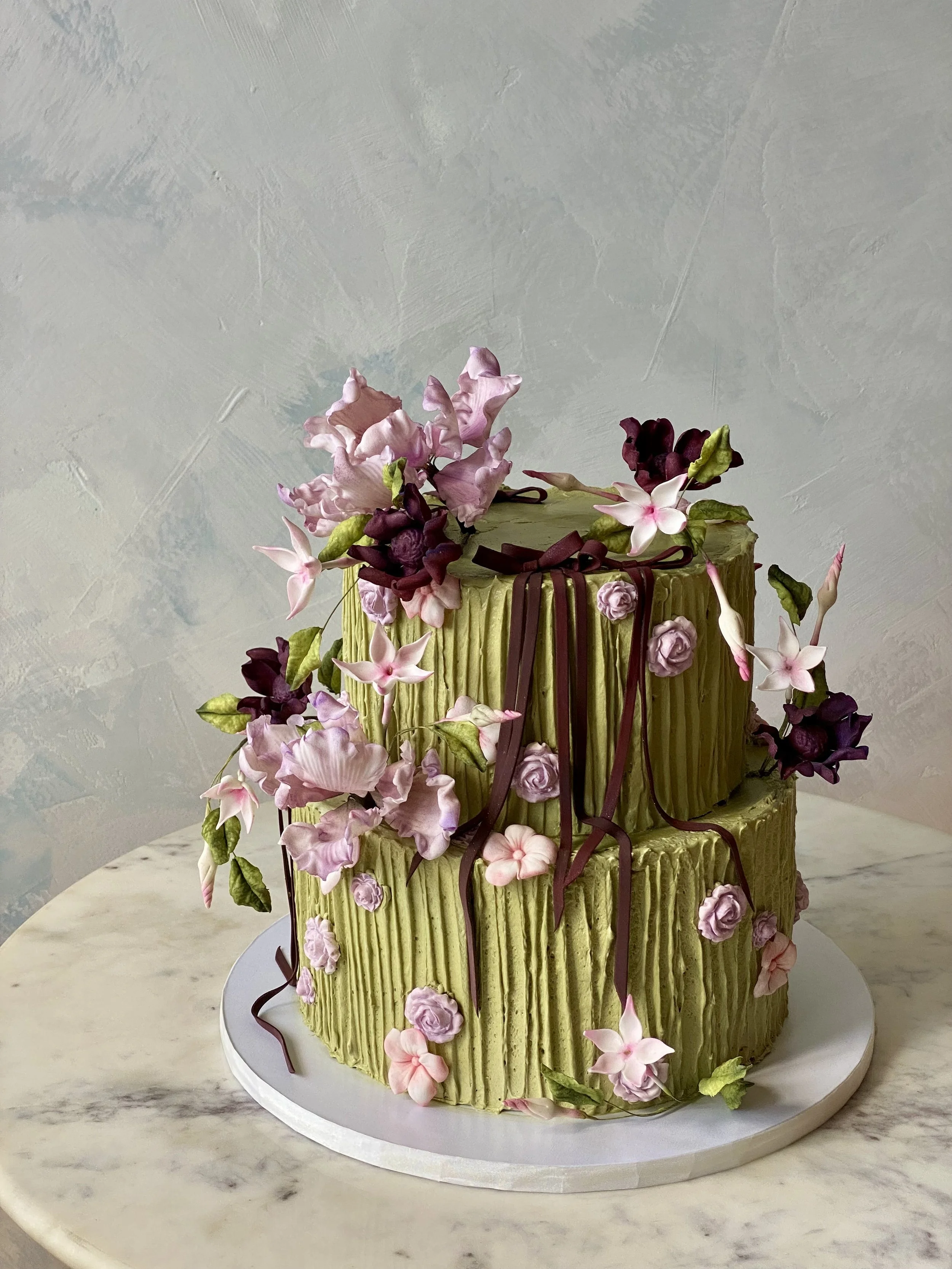 Matcha green tea textured icing with sugar flowers and bows for a wedding cake thats organic and gluten-free. 
