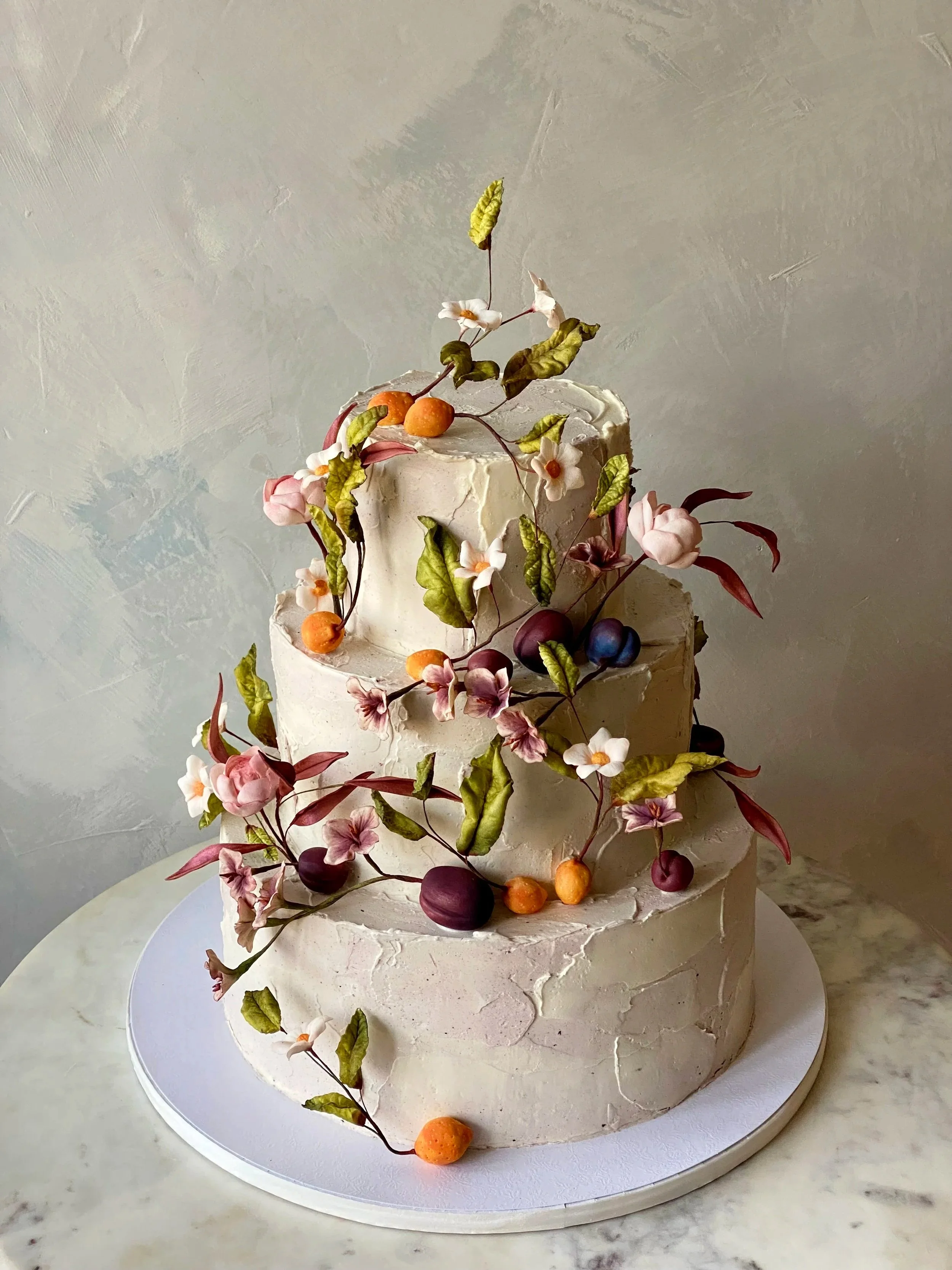Pastel icing wedding cake with stone fruit, flowers and a romantic delicate whimsical design in New York. 