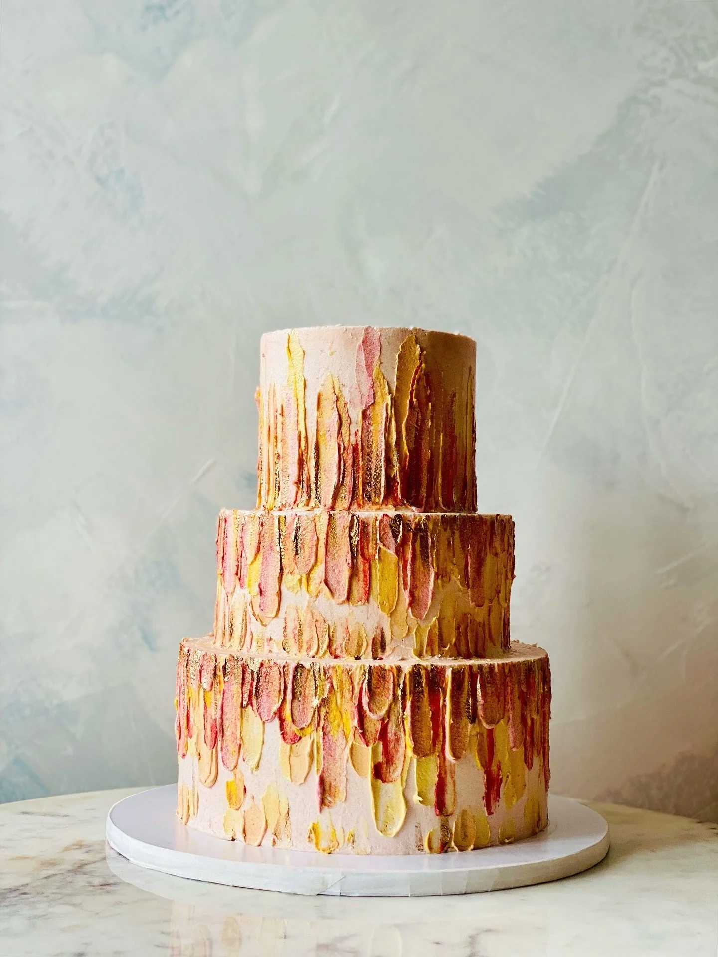 Painting icing strokes that are colorful, vibrant and sunset theme for a gluten-free birthday cake in NYC. 