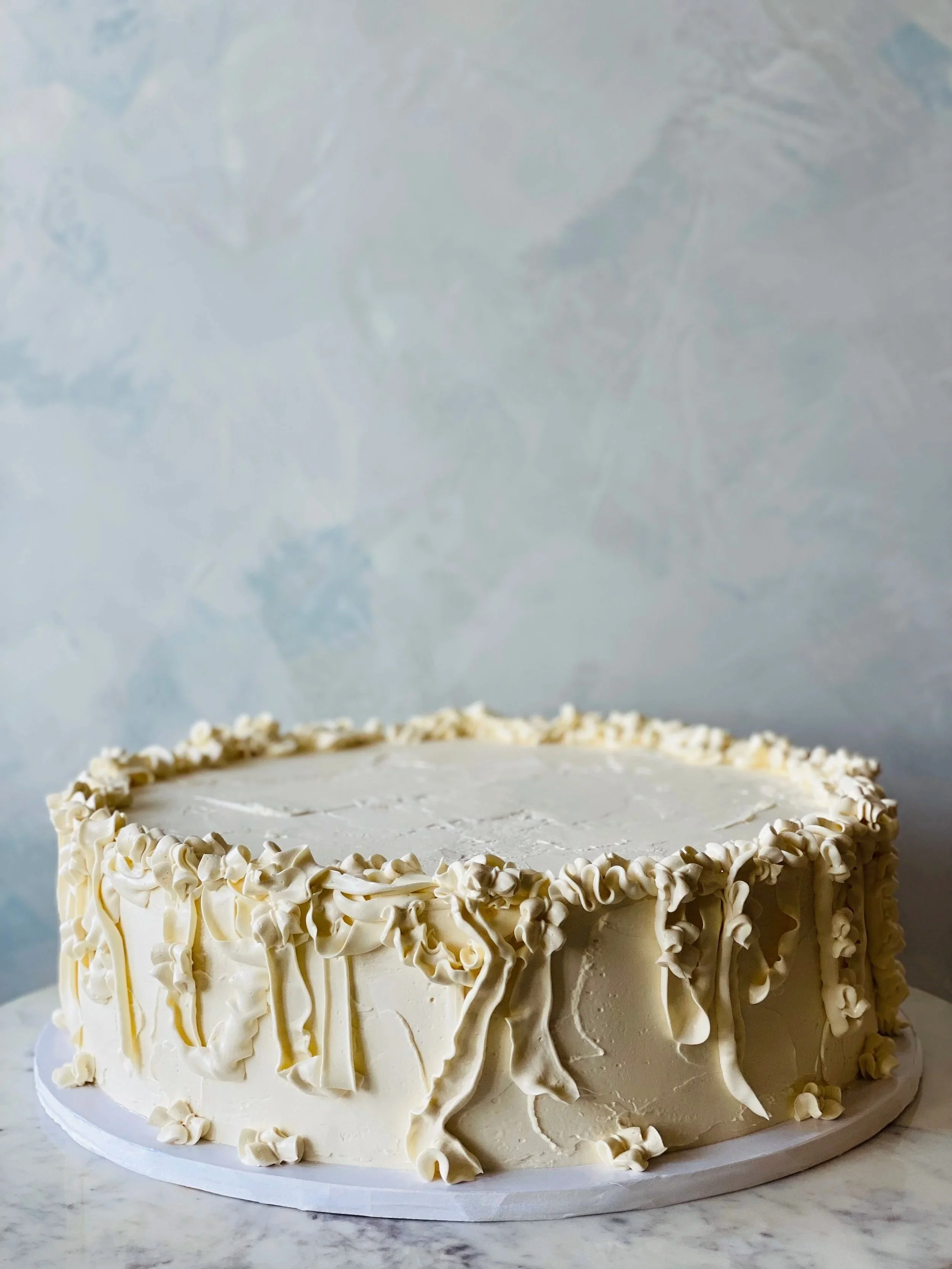 Large single tier gluten-free wedding cake with organic romantic ruffle pipping for a berry ceremony.  
