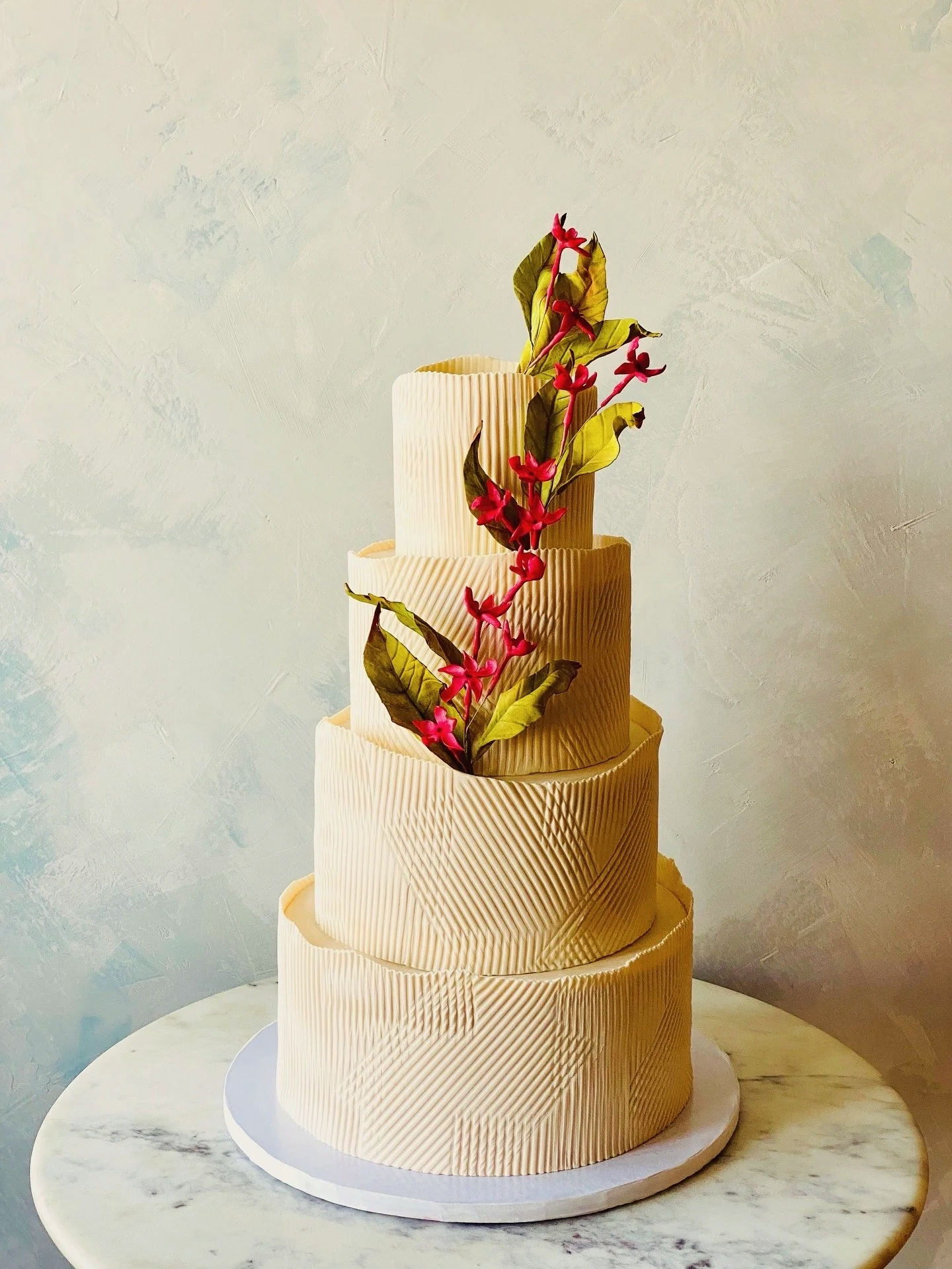 Sculptural textured tall organic, gluten-free, and vegan wedding cake with tropical unique flowers that's contemporary and unique. 