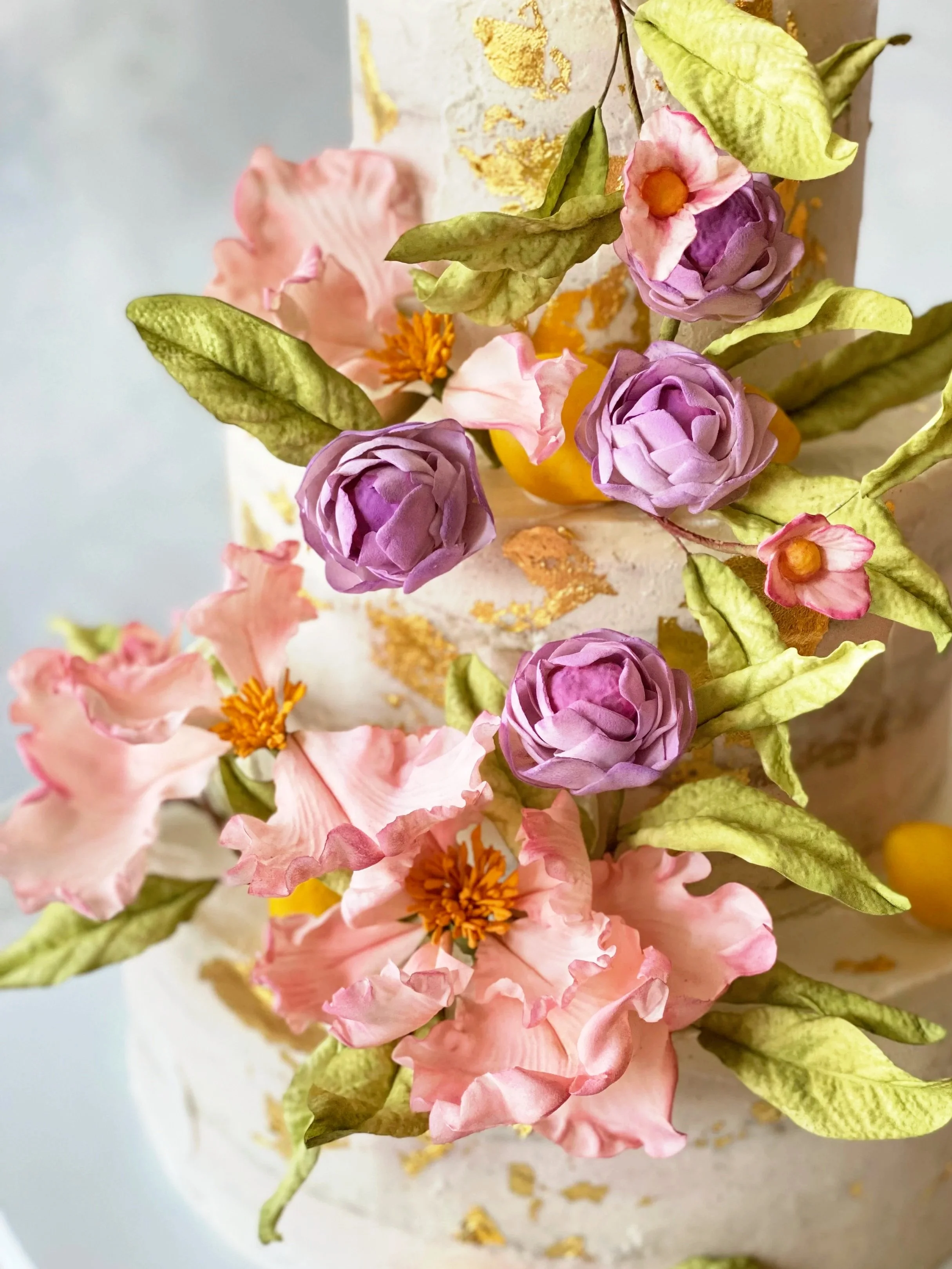 Pastel sugar flowers with gold leaf on vegan, gluten-free, organic tiered wedding cake in NYC.