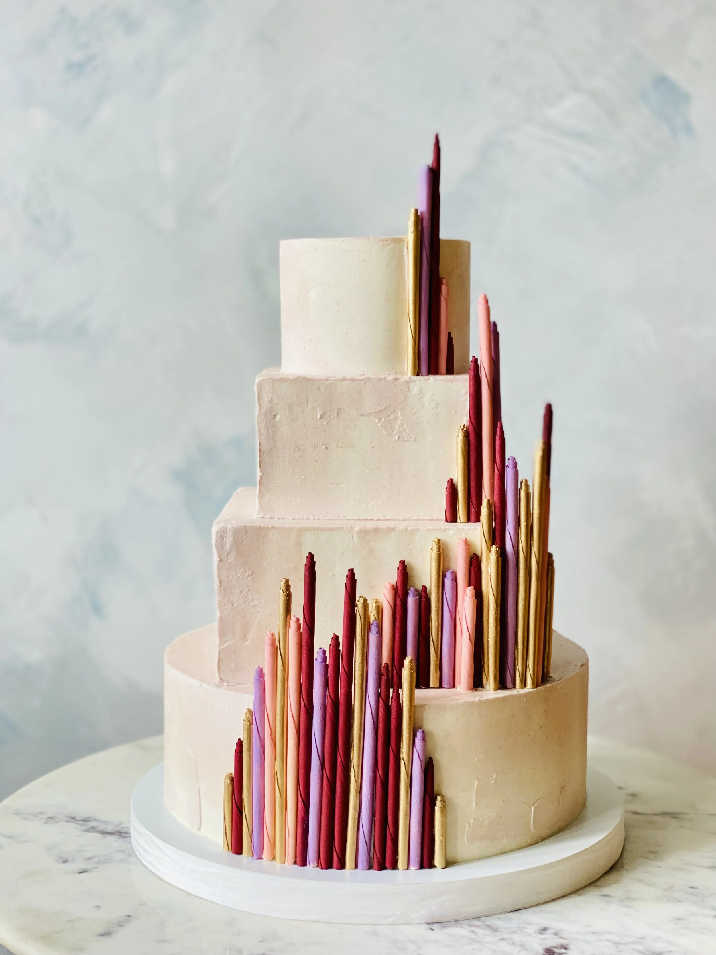 Modern art deco colorful white chocolate curls on a pink iced gluten-free, vegan cake in Brooklyn, NY.