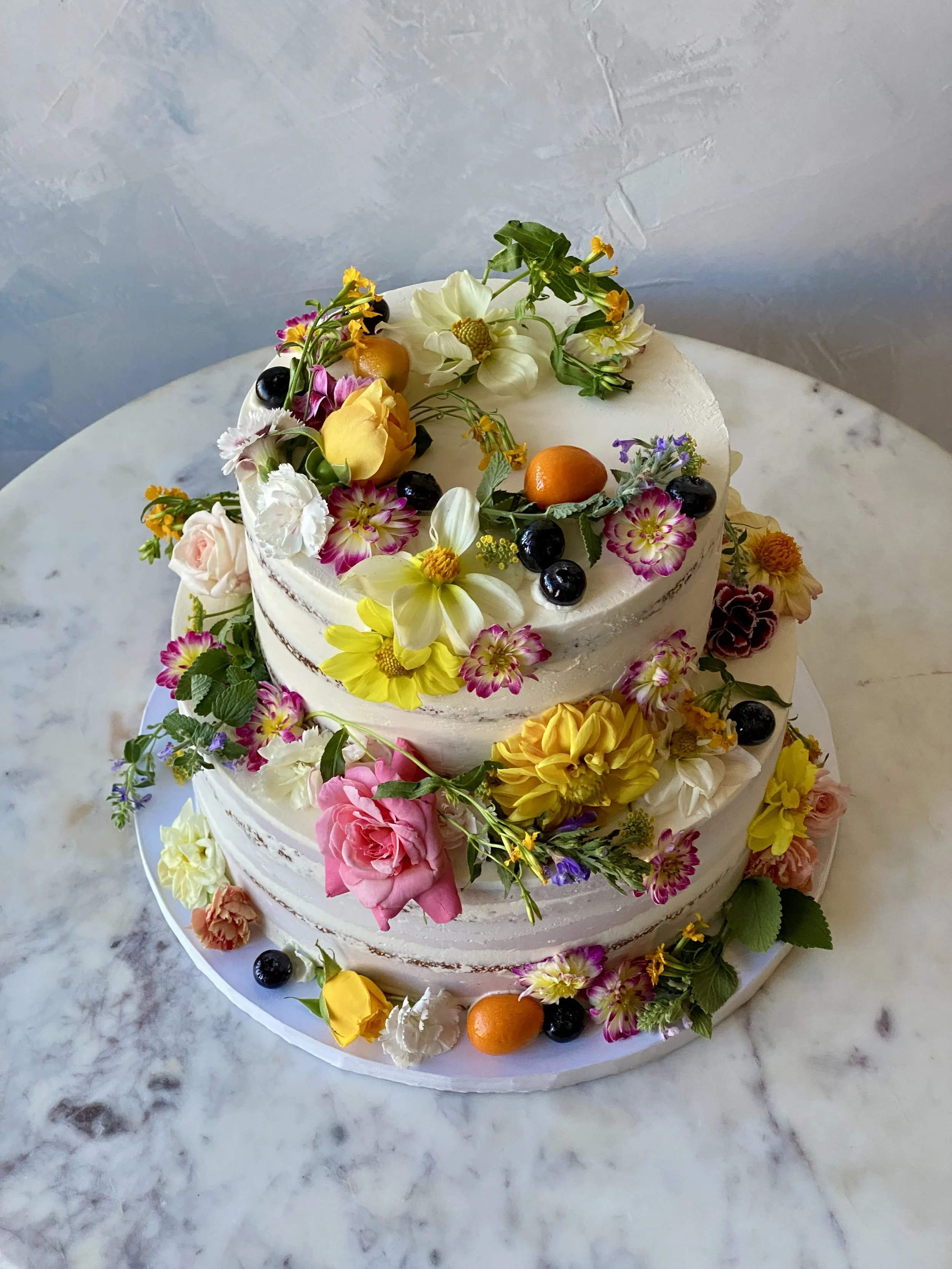 Edible flowers, herbs, berries and citrus transparent icing for an organic, gluten-free wedding. 