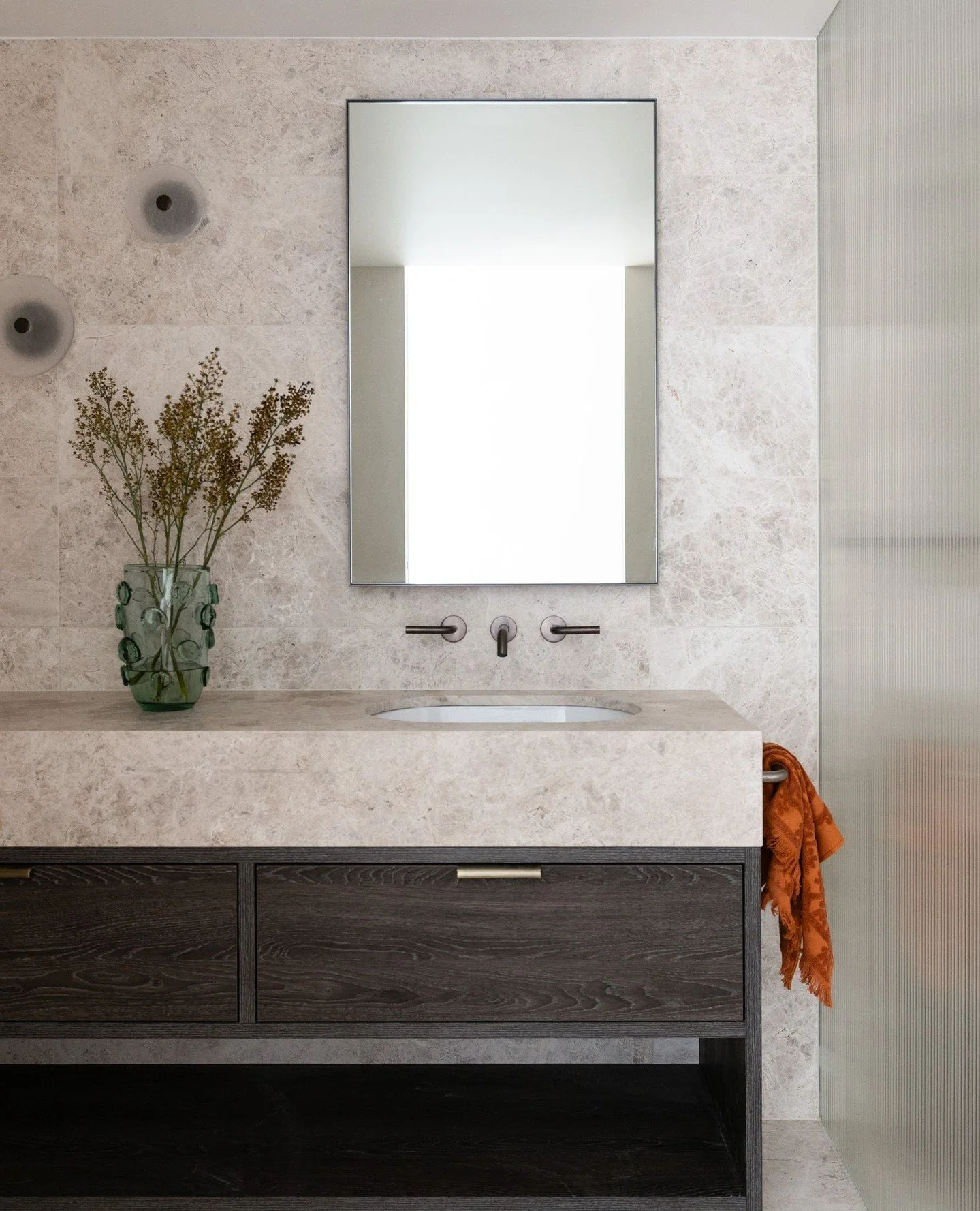 A sanctuary of texture and warmth. In the main bathroom at our Walsh Bay Apartment project, deep timber veneer balances the organic movement of natural stone, creating a space that feels calm yet sophisticated.⁠
⁠
Custom cabinetry and mirror detailin
