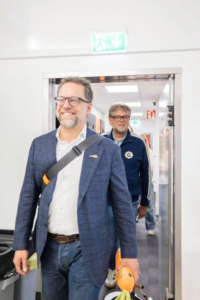 Jascha Rohr zu Besuch bei Ratatouille Catering. Im Vordergrund ist Jascha Rohr und im Hintergrund sieht man André Adden, beide lächeln in die Kamera.