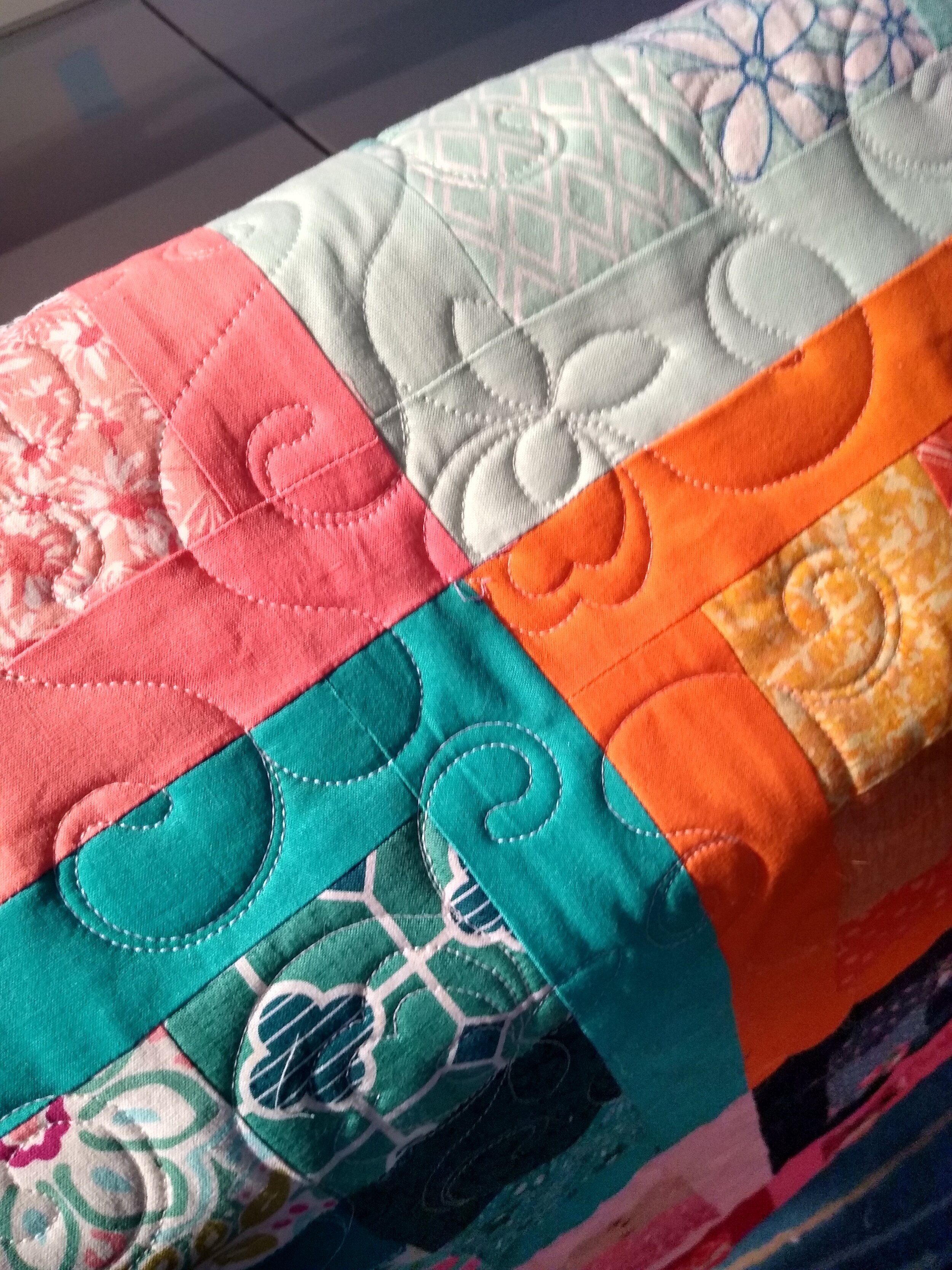 Colorful patchwork quilt with various patterns and stitching designs