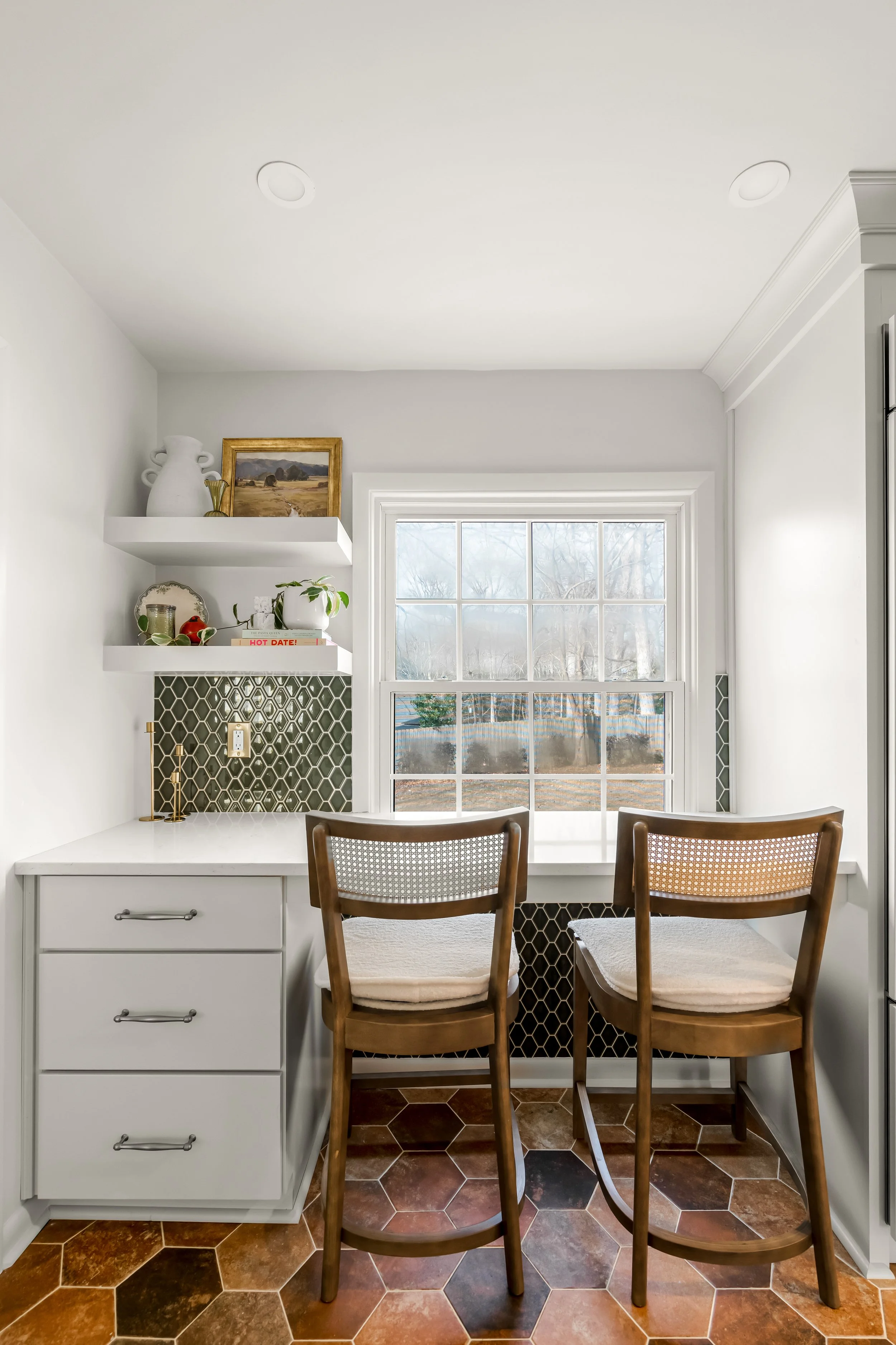 Breakfast bar in a Williamsburg, Virginia kitchen remodel overlooking the backyard, with custom cabinetry and paneled appliances by AWH Interiors.