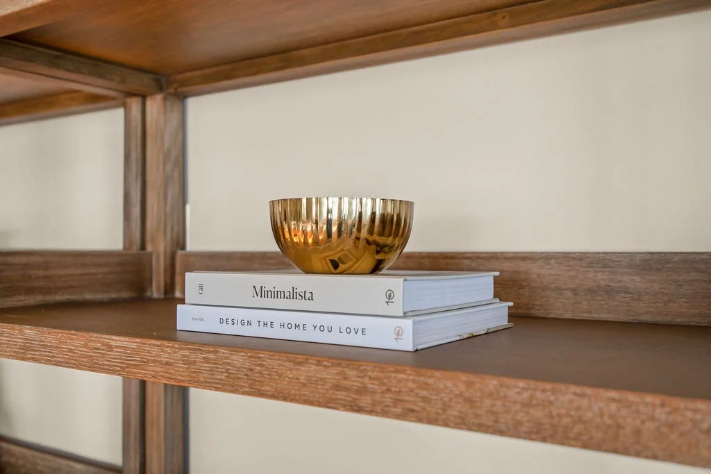 Spacious waterfront living room designed by AWH Interiors in Williamsburg, featuring soft blue accents, layered neutrals, and natural wood tones that echo the coastal surroundings.
