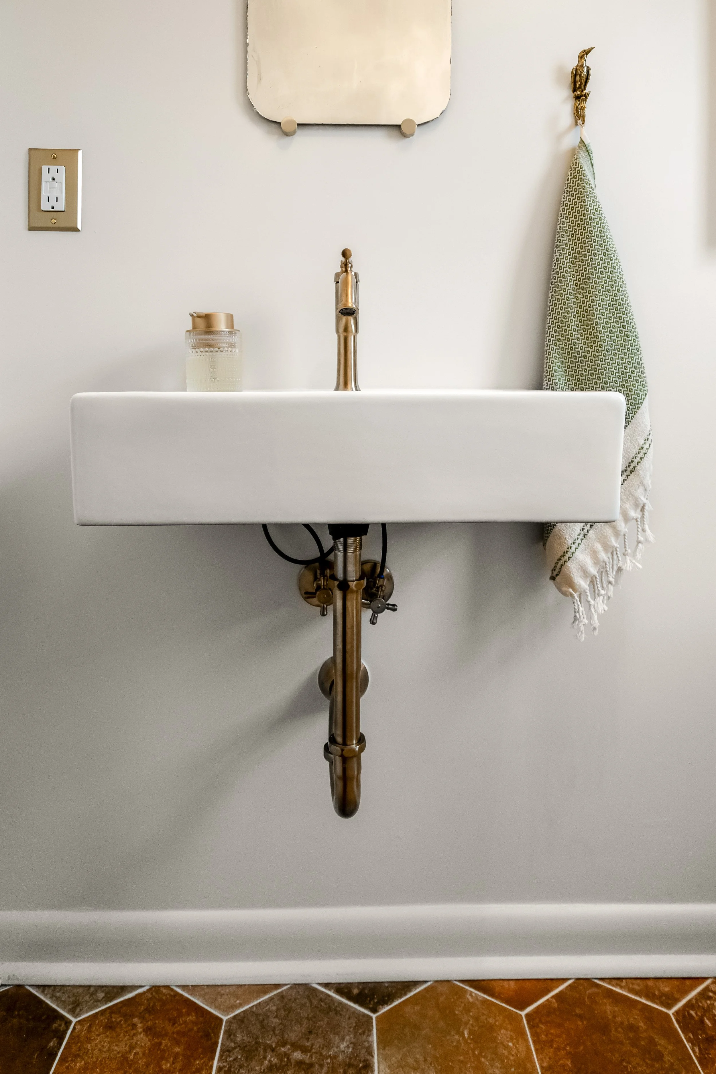 Powder room vanity and finishes in a Williamsburg, VA remodel created by converting the home’s former laundry room into a guest powder bath. Designed by AWH Interiors.