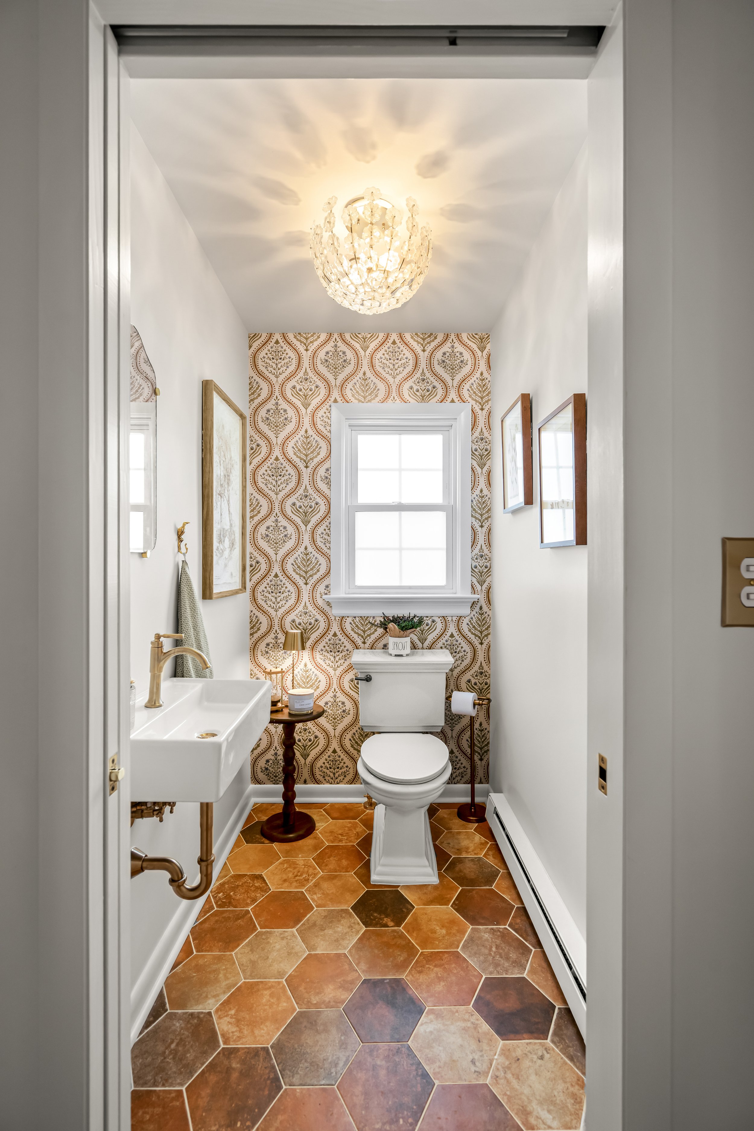 Powder room in a Williamsburg, Virginia kitchen remodel created by relocating the home’s original laundry room and transforming the space into a charming guest powder bath. Designed by AWH Interiors.