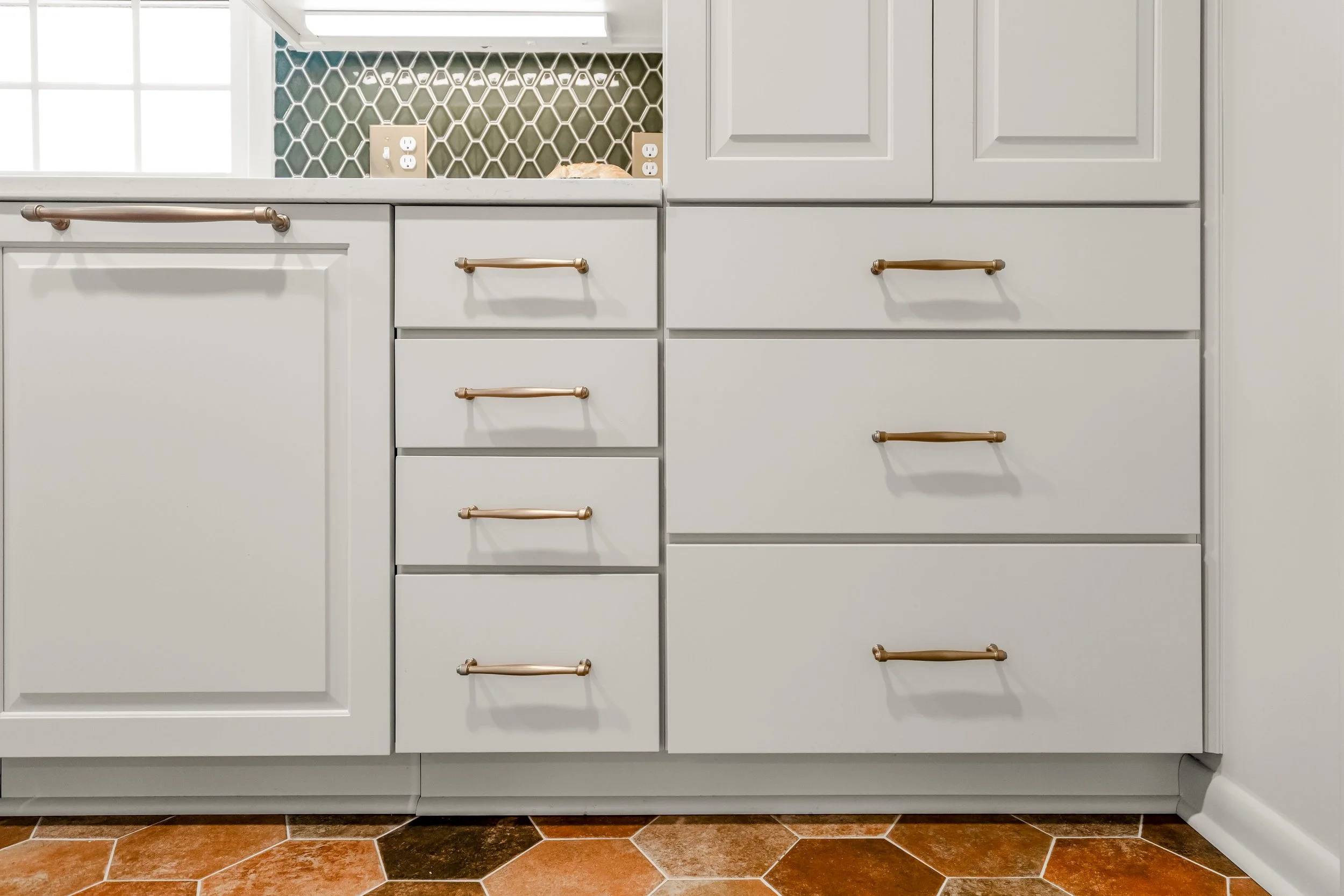 Williamsburg, VA custom galley kitchen remodel with terracotta hex tile floors, white cabinetry, chef-grade range, and brass hardware by AWH Interiors.