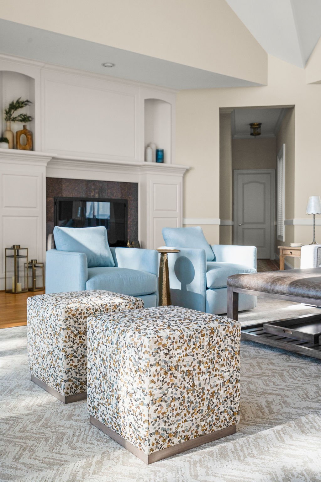 Spacious waterfront living room designed by AWH Interiors in Williamsburg, featuring soft blue accents, layered neutrals, and natural wood tones that echo the coastal surroundings.