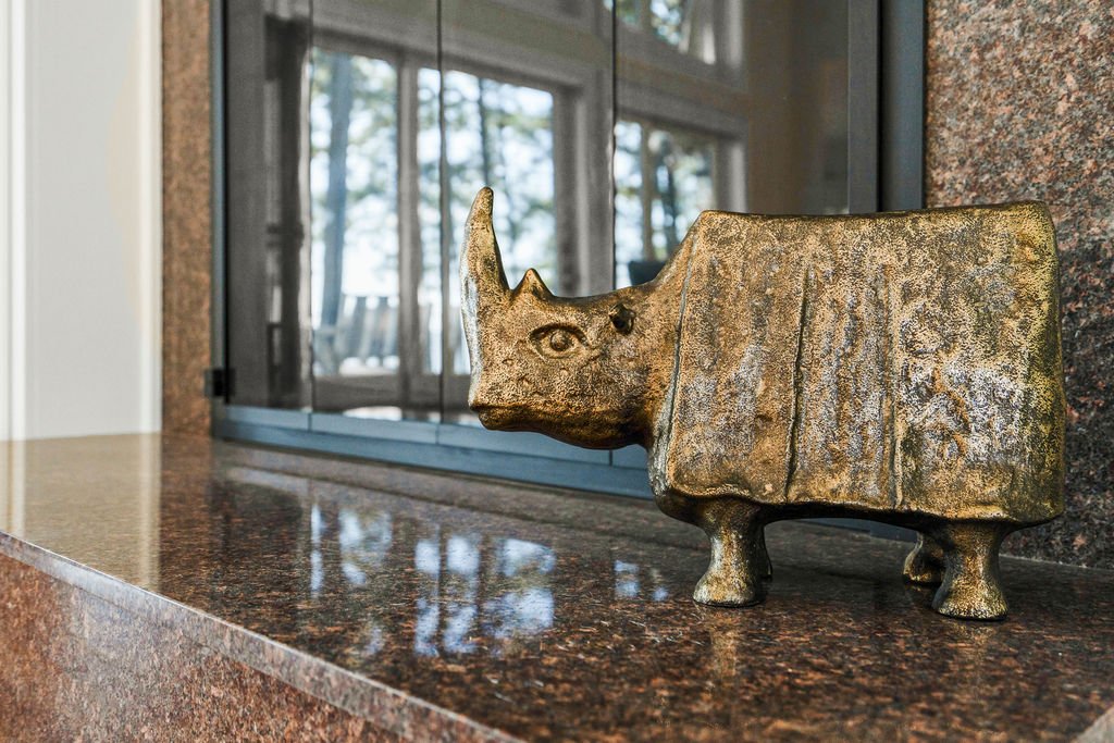 Spacious waterfront living room designed by AWH Interiors in Williamsburg, featuring soft blue accents, layered neutrals, and natural wood tones that echo the coastal surroundings.