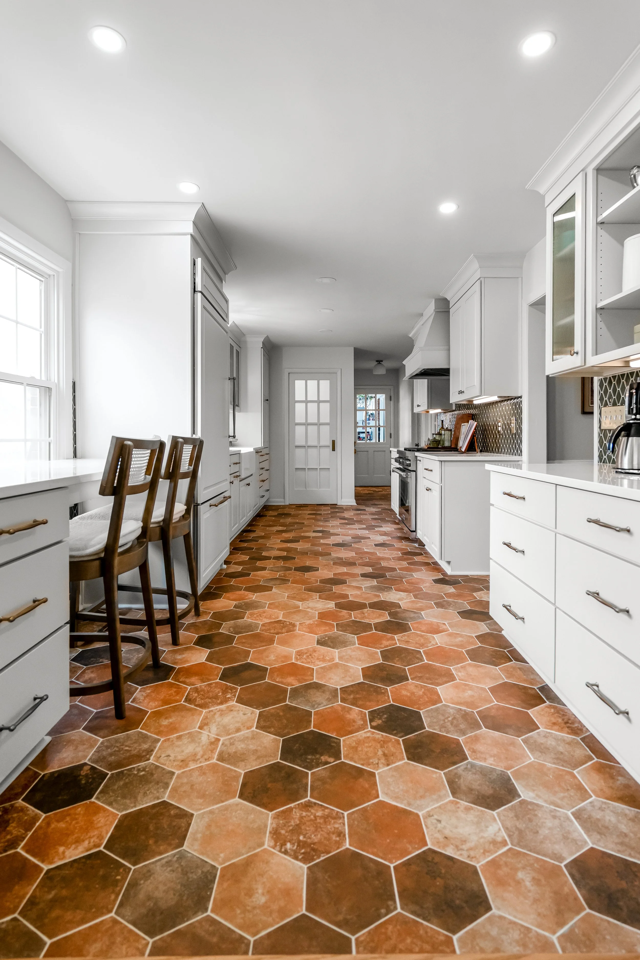 Breakfast bar in a Williamsburg, Virginia kitchen remodel overlooking the backyard, with custom cabinetry and paneled appliances by AWH Interiors.