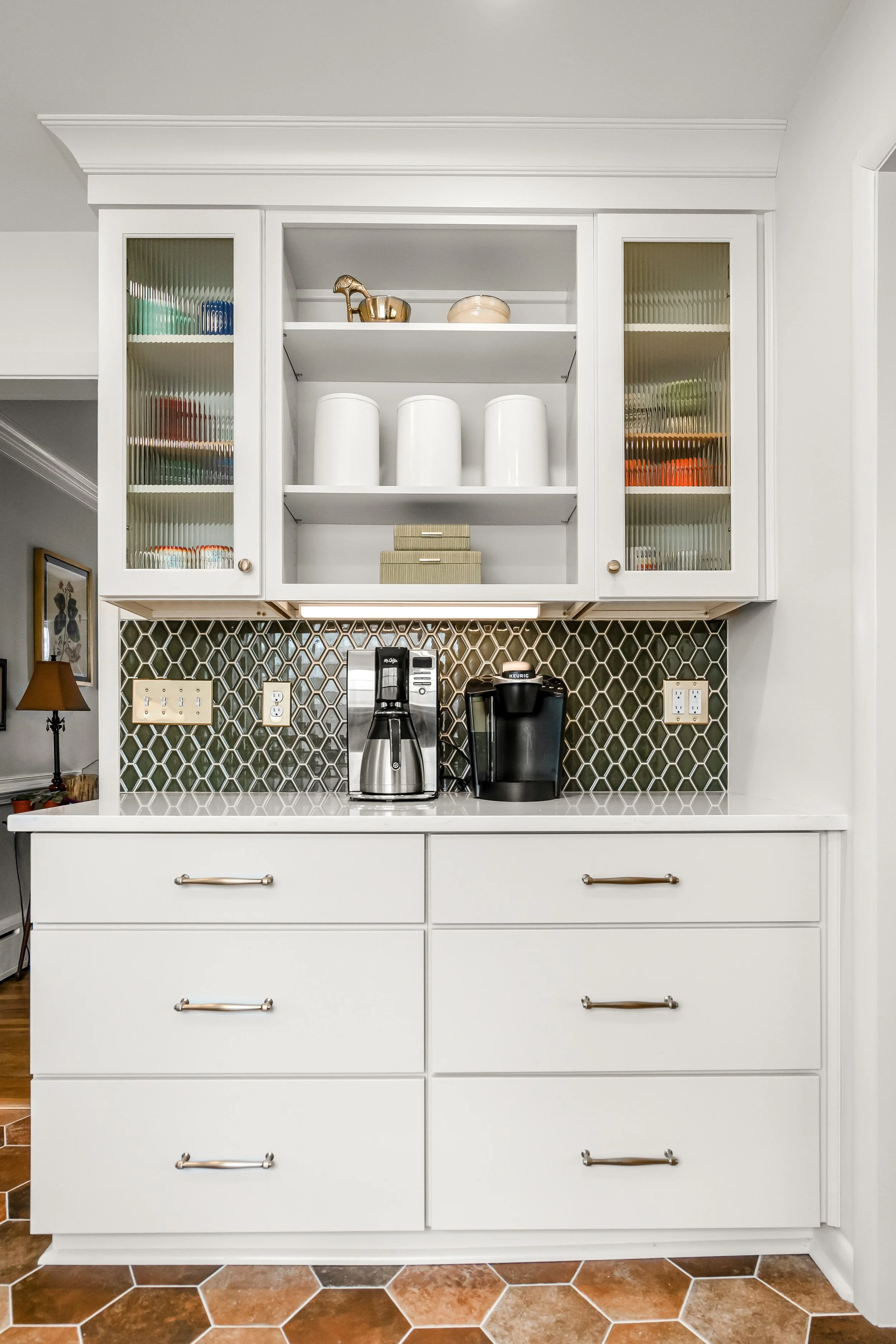 Williamsburg, VA custom galley kitchen remodel with terracotta hex tile floors, white cabinetry, chef-grade range, and brass hardware by AWH Interiors.