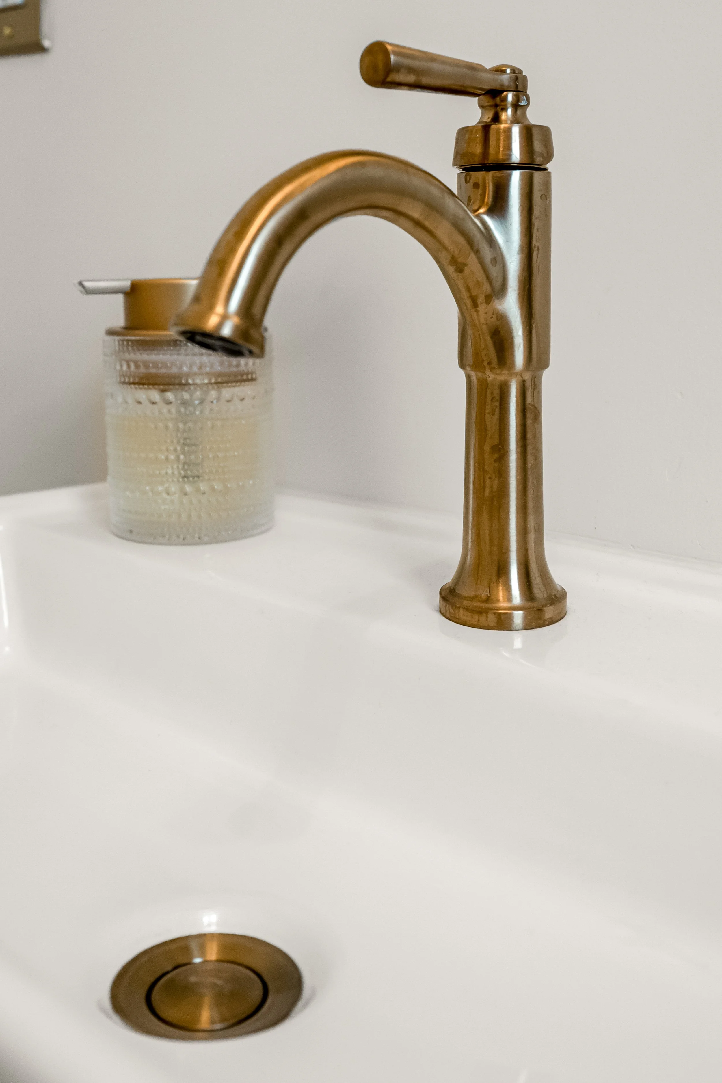 Powder room vanity and finishes in a Williamsburg, VA remodel created by converting the home’s former laundry room into a guest powder bath. Designed by AWH Interiors.