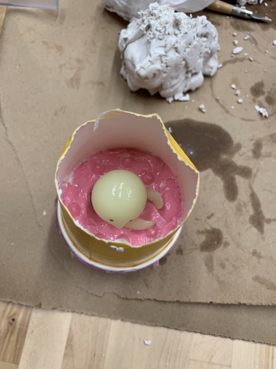 The yellow cup provides the structure before pouring the second half of the silicone