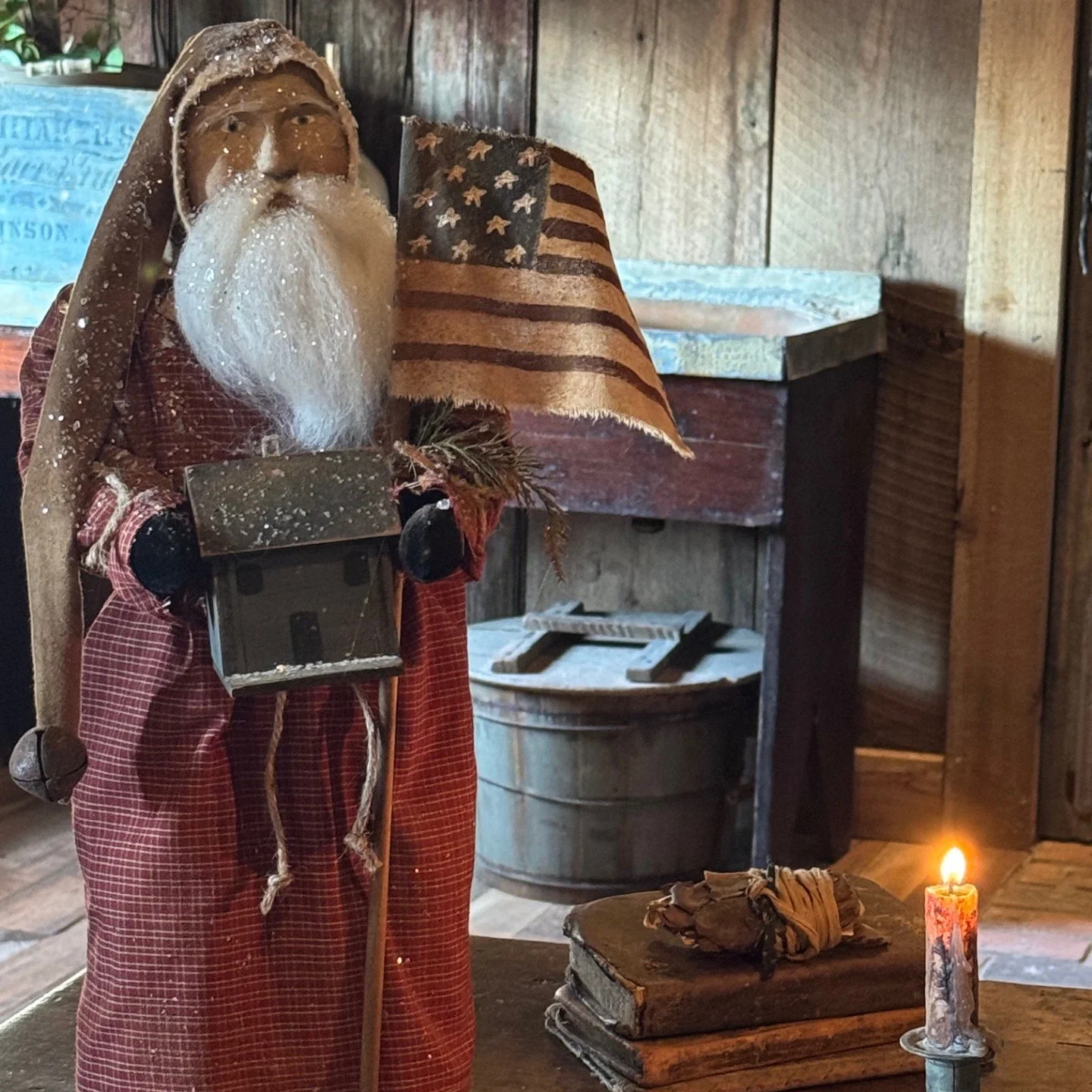 2026 Santa wearing a red homespun coat holding a blue house and flag