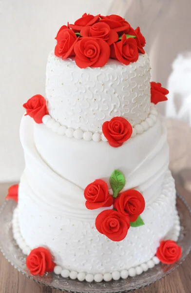 Traditional wedding cake with red roses.
