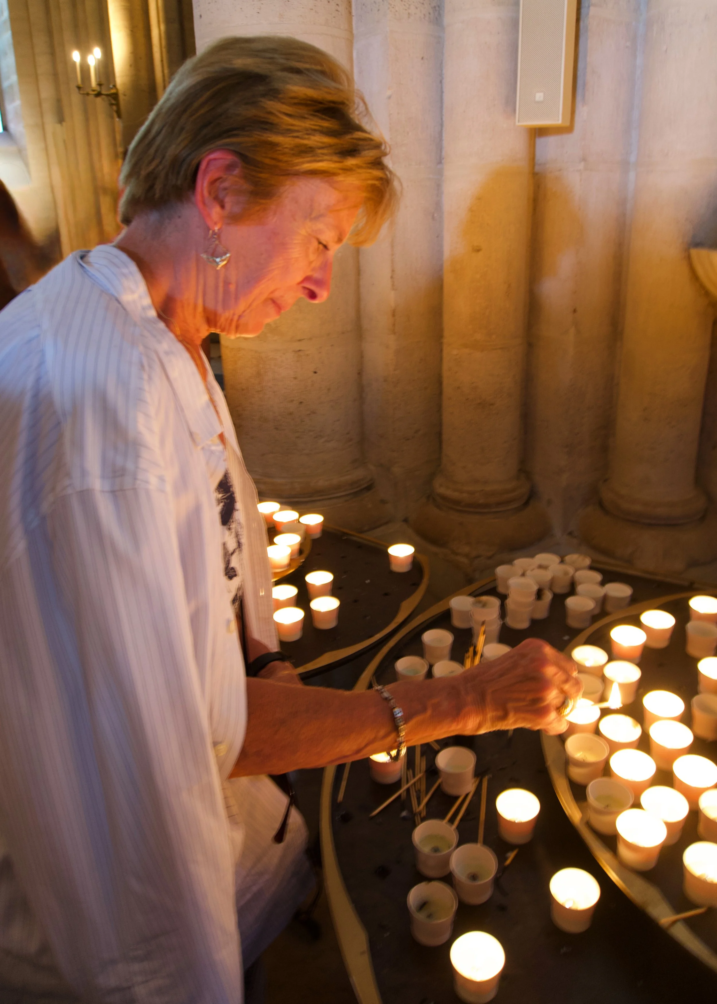 Lighting a  prayer candle in Notre Dame Cathedral