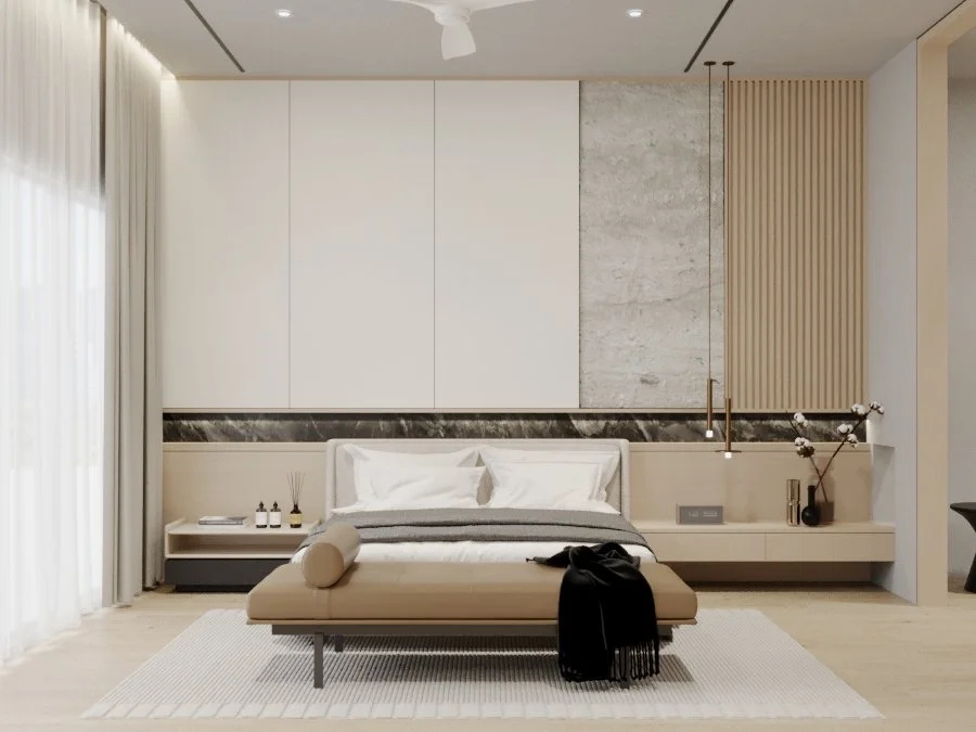 Modern bedroom with a neutral color palette, featuring a bed with white sheets, beige bench at the foot, and a large window with white curtains. The wall behind the bed has a mixed texture of marble and wood paneling, with minimalistic decor and pend