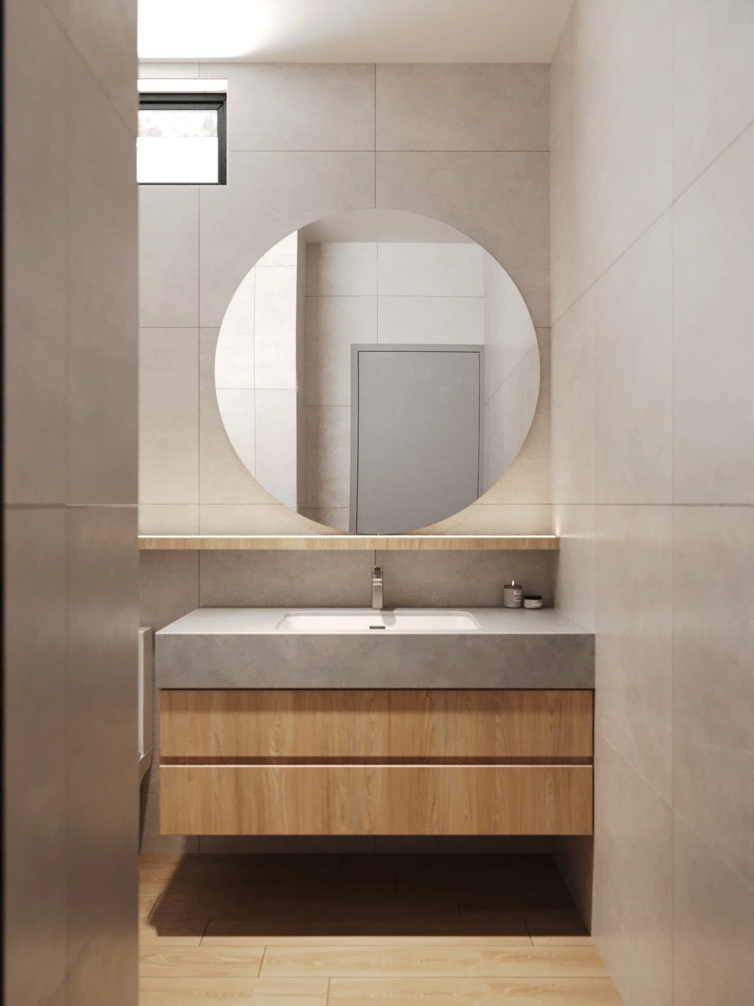 Modern bathroom with a round mirror above a wooden vanity with a concrete sink, wall-mounted faucet, beige tiled walls, a small window, and a gray door in the background.