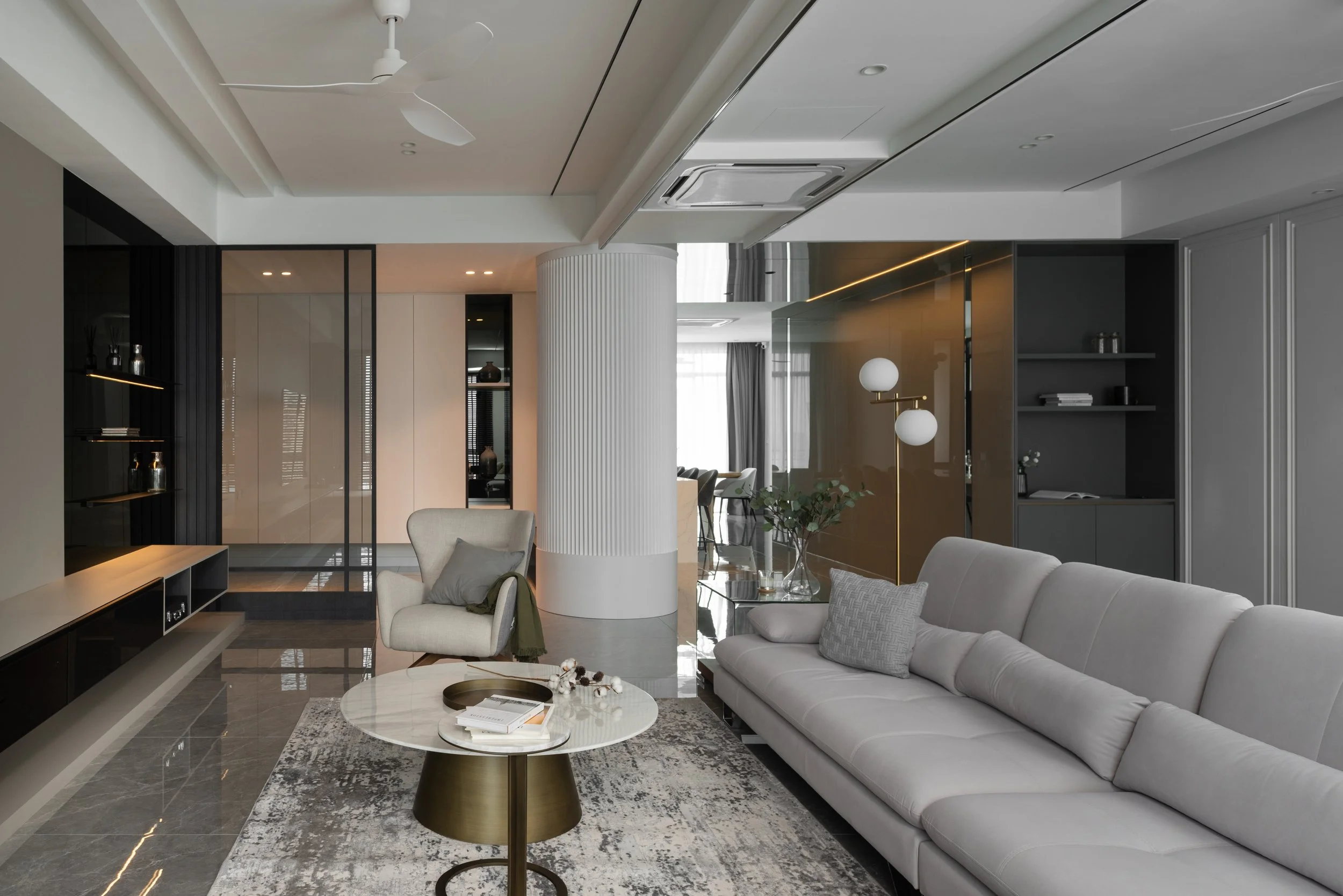 Modern living room with white sofa, armchair, coffee table, and decorative lighting, featuring neutral tones and sleek design.