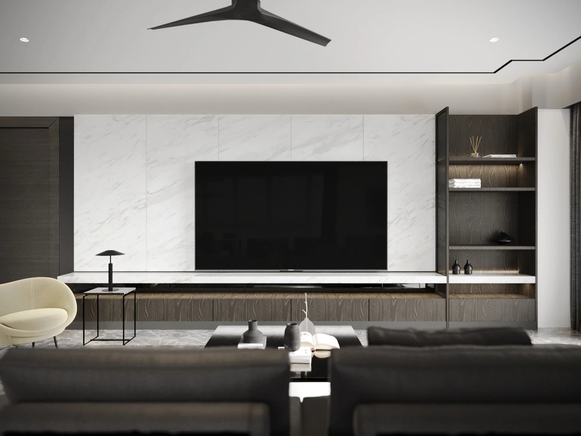 Modern living room with a large flat-screen TV mounted on a white marble accent wall, black and beige seating, a black side table with a lamp, and a dark wood bookshelf with decorative items, all in a minimalist style.