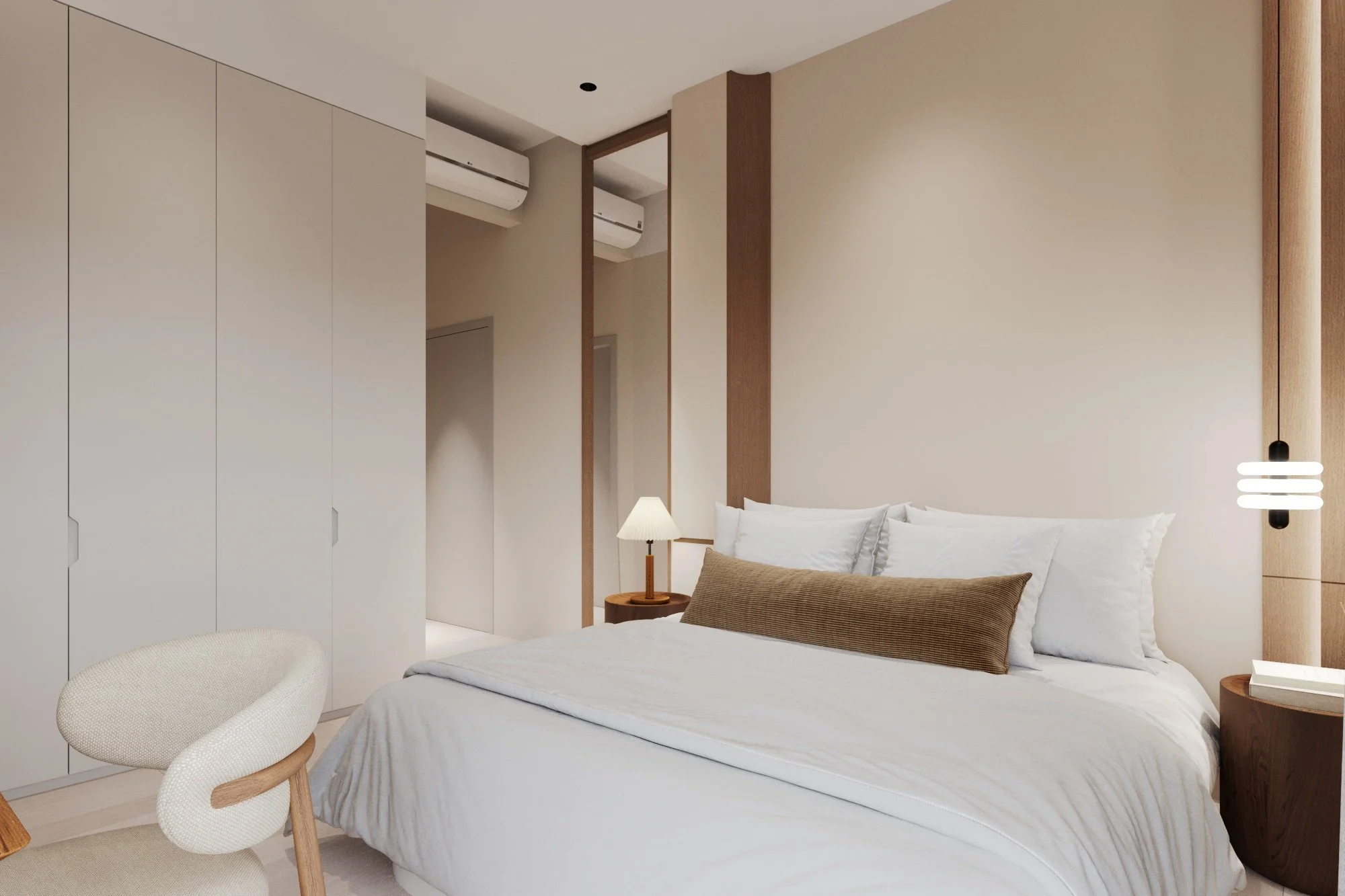 A modern bedroom with a bed featuring white linens and multiple pillows, a bedside table with a lamp, a beige chair, built-in wardrobe, and air conditioning units on the wall.