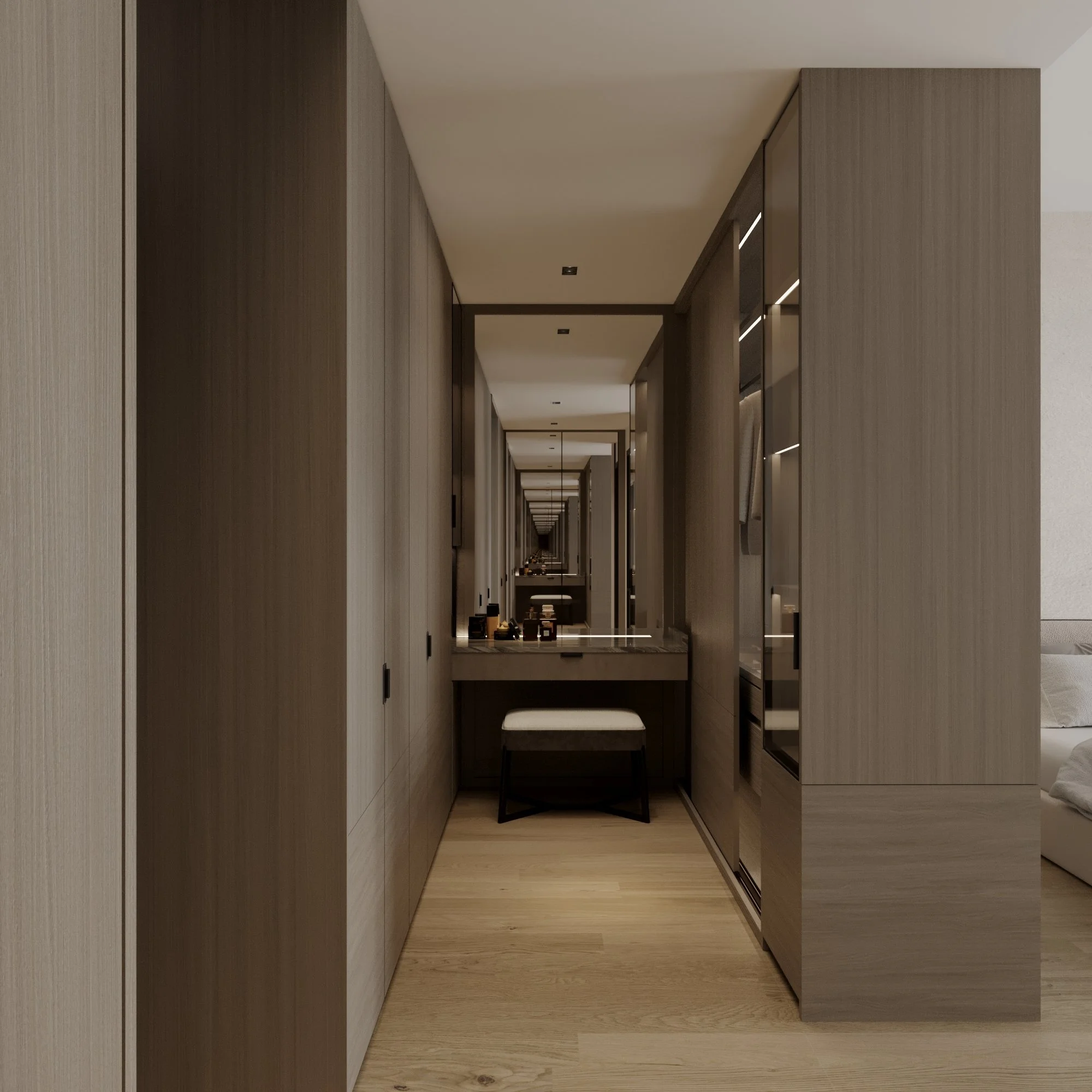 A narrow hotel room with wall-to-wall wood panels, a mirror creating a visual illusion of infinite space, and a small desk with a cushioned stool, leading to a bed area.
