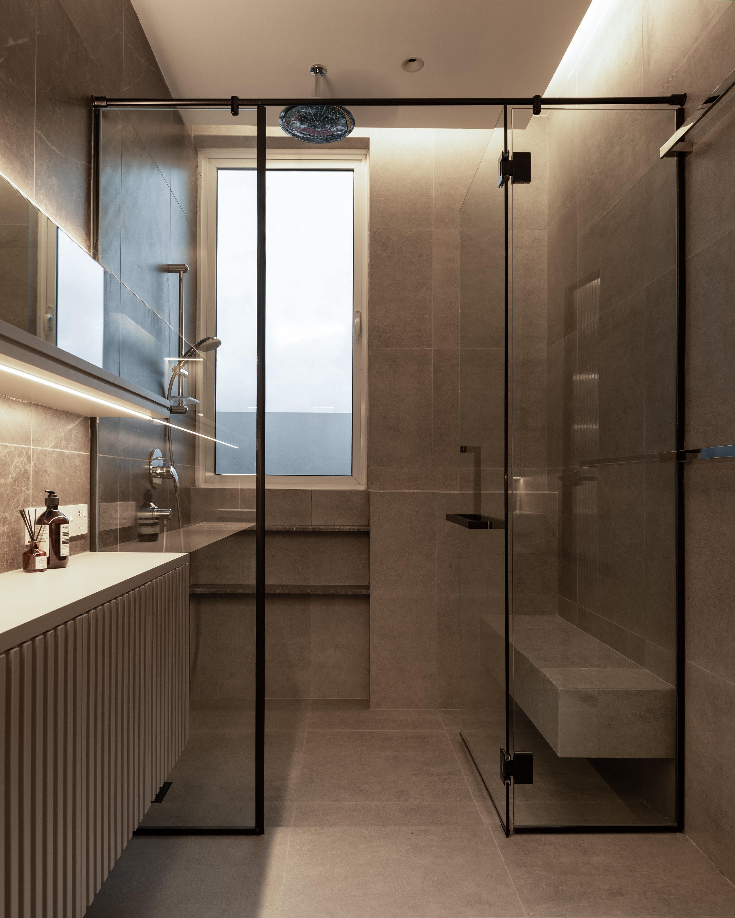 Modern bathroom with a walk-in shower, window, and minimalistic decor.