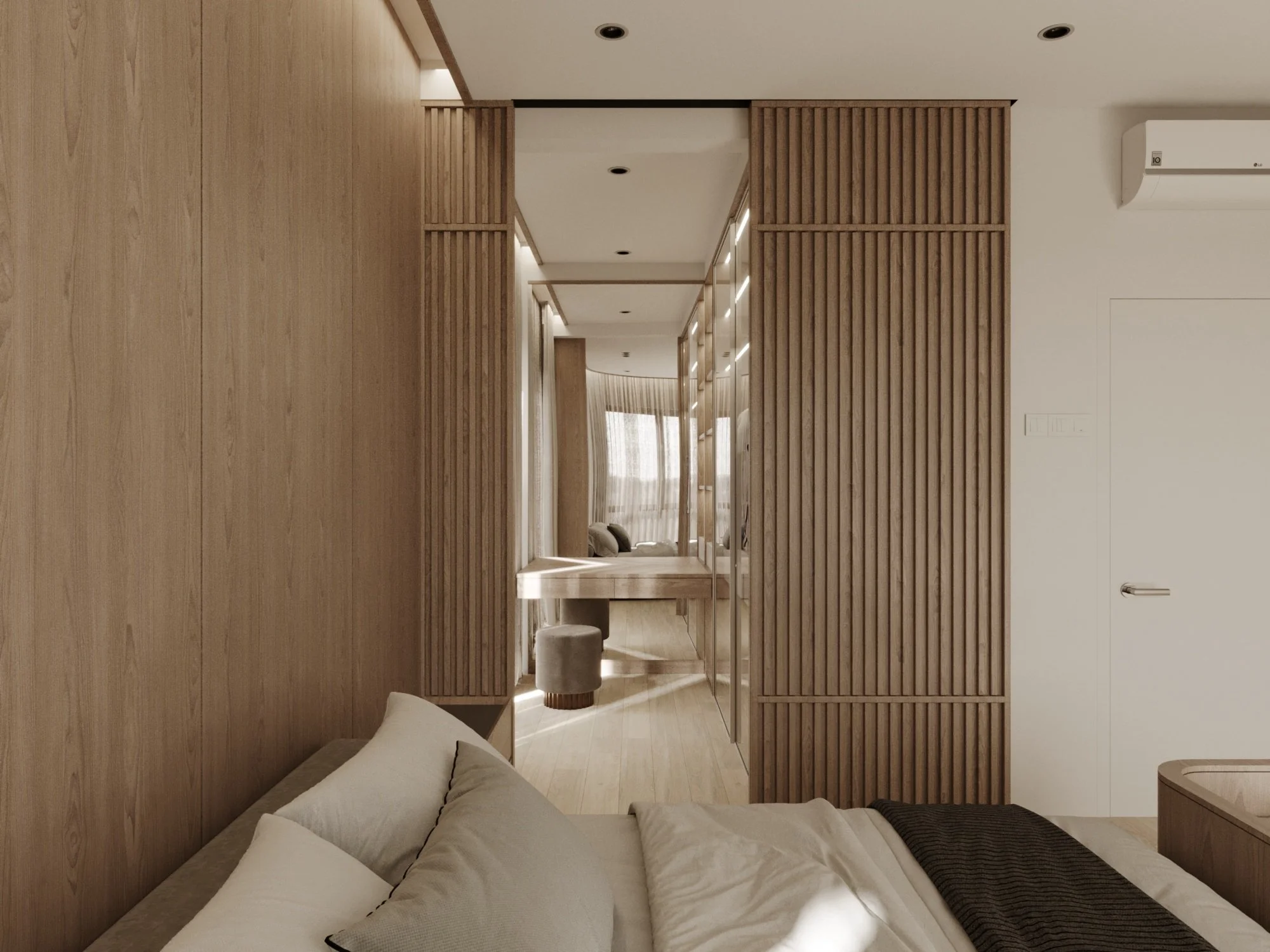 Modern bedroom with wooden paneling, a bed with neutral-colored pillows, a desk or vanity area with a stool, and an adjoining sitting area with large windows and sheer curtains.