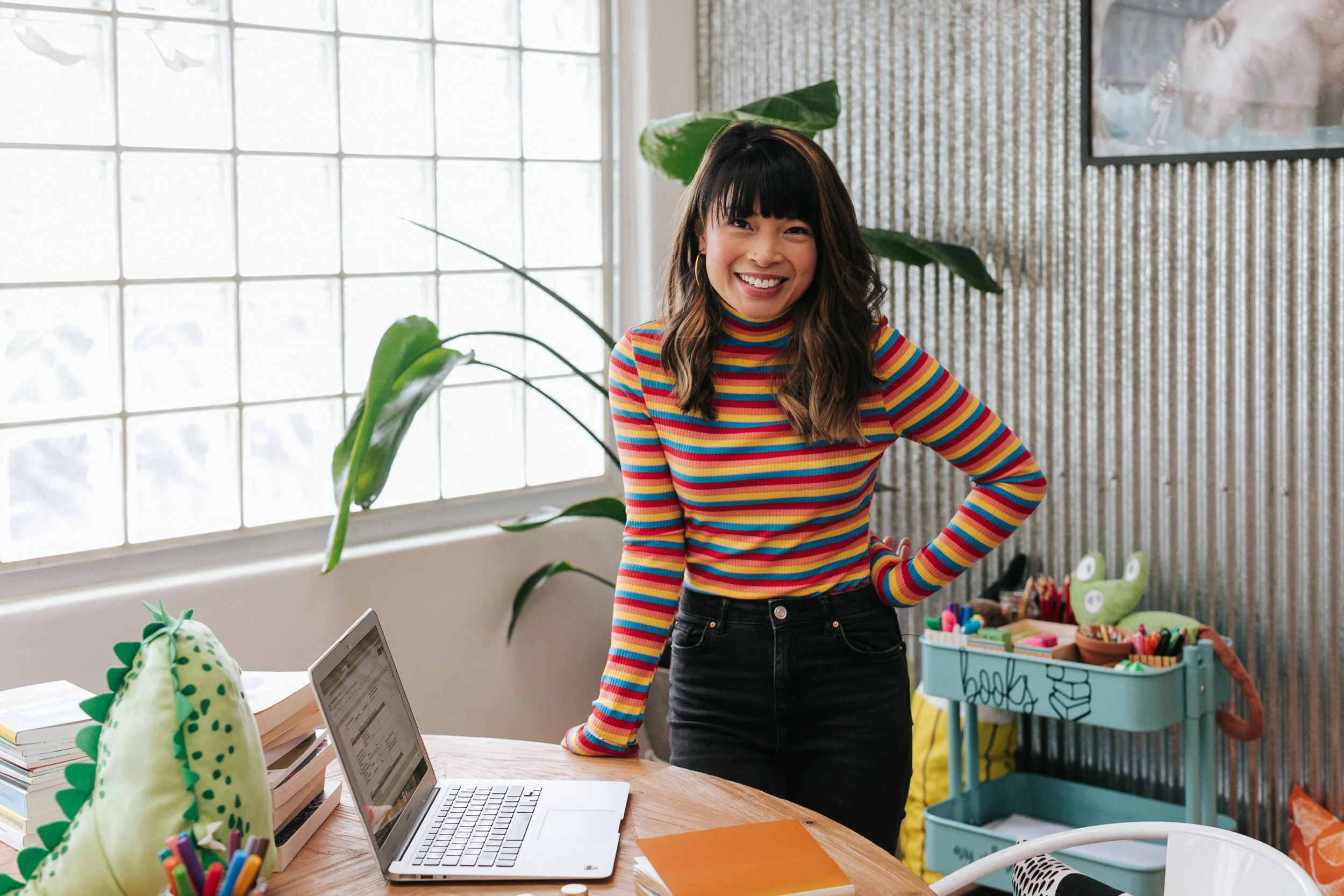 Amy Han smiling as she stands in her creative writing studio ready to teach online creative writing sessions for kids.