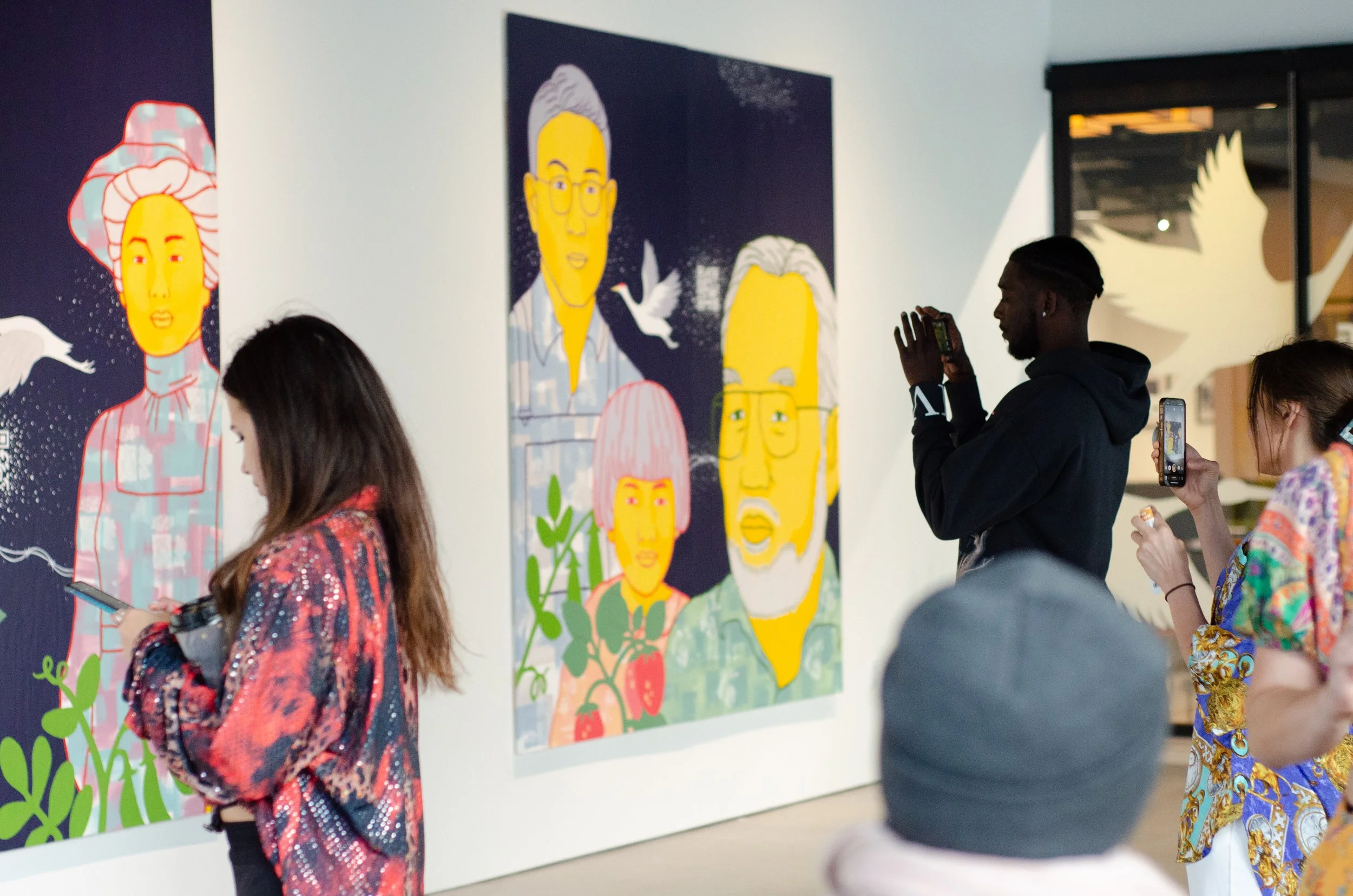 Patrons in the gallery viewing the artwork