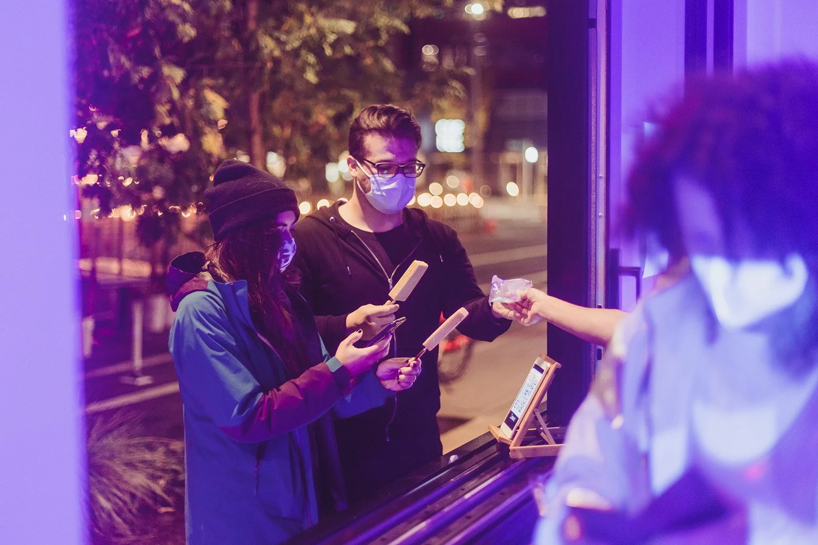 Two people at a window ordering AR+Pops